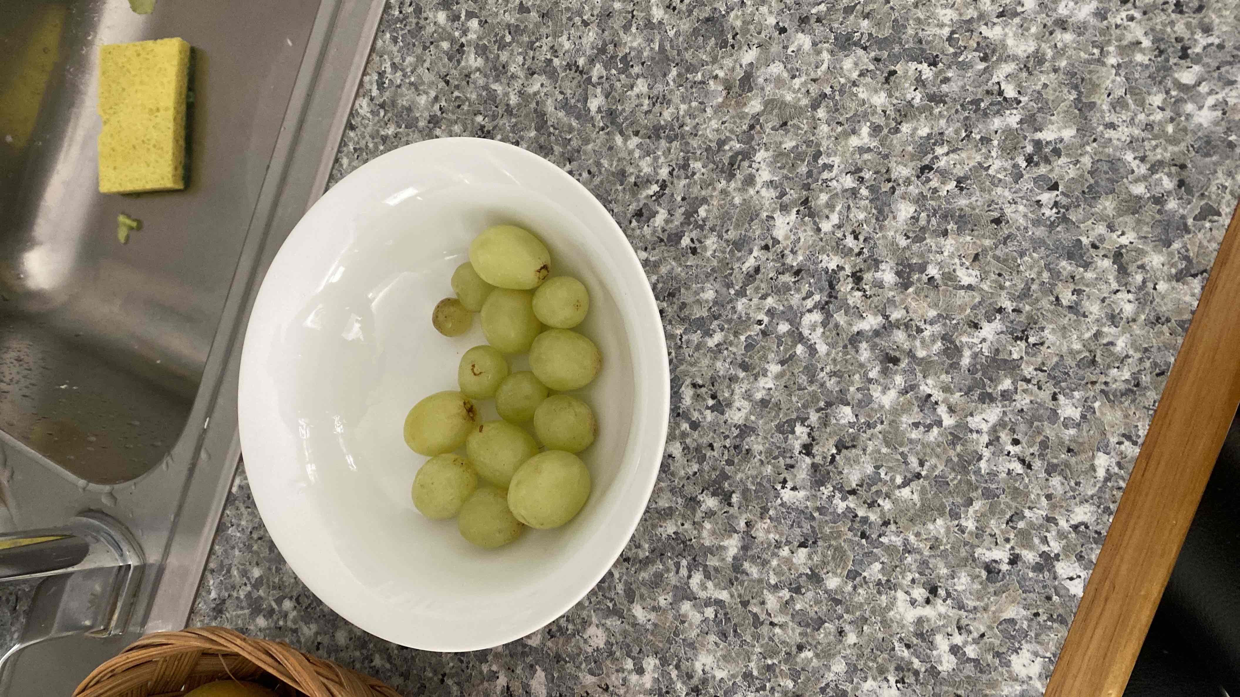 A bowl of green grapes, a low-calorie fruit rich in carbohydrates and minimal fats, suitable for a healthy snack.