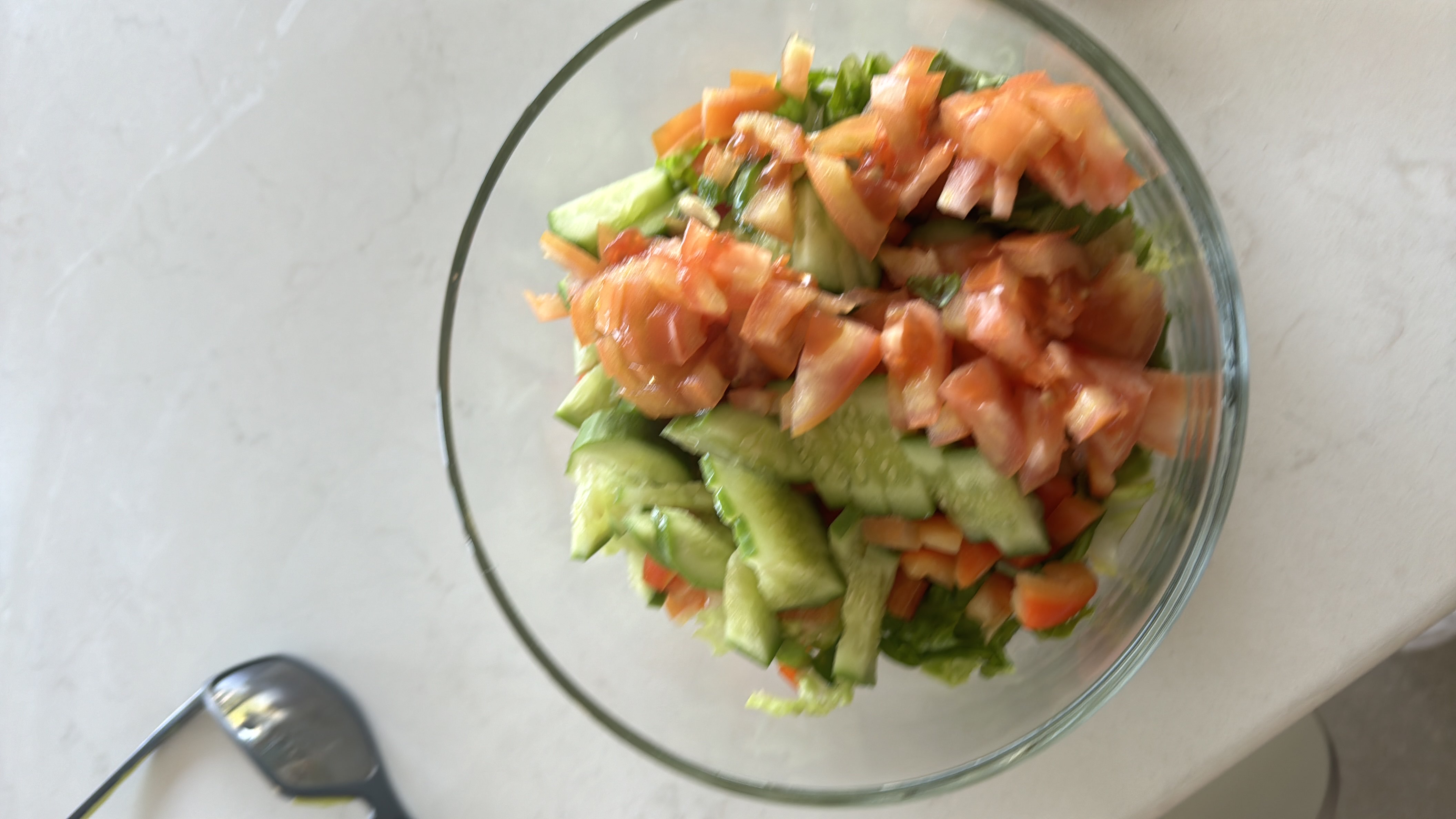 A fresh vegetable salad containing cucumbers, tomatoes, lettuce, and carrots, offering a low-calorie, nutrient-rich meal.