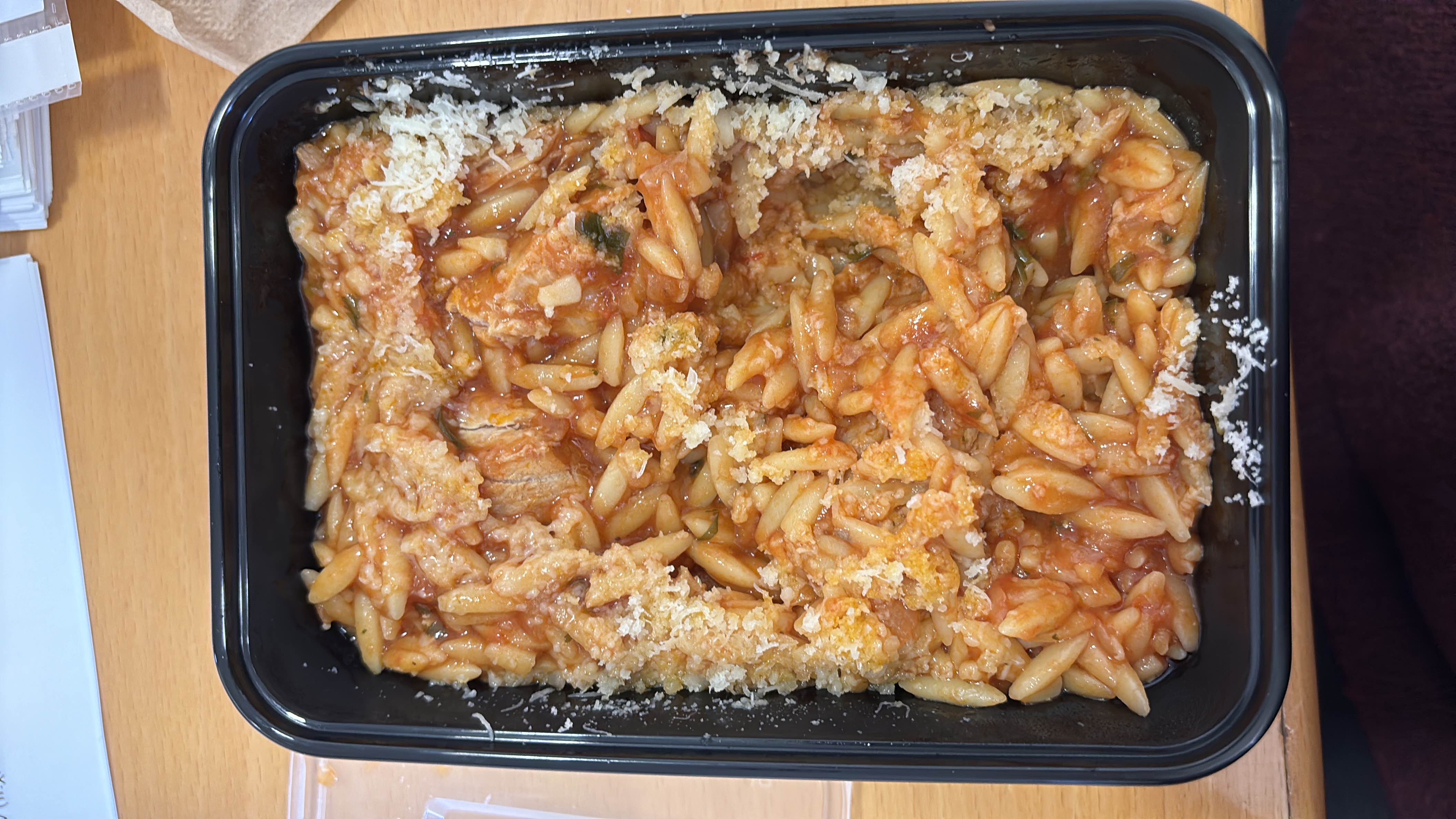 A serving of baked pasta with tomato sauce, cheese, and meat, providing a balanced mix of carbs, protein, and fats.