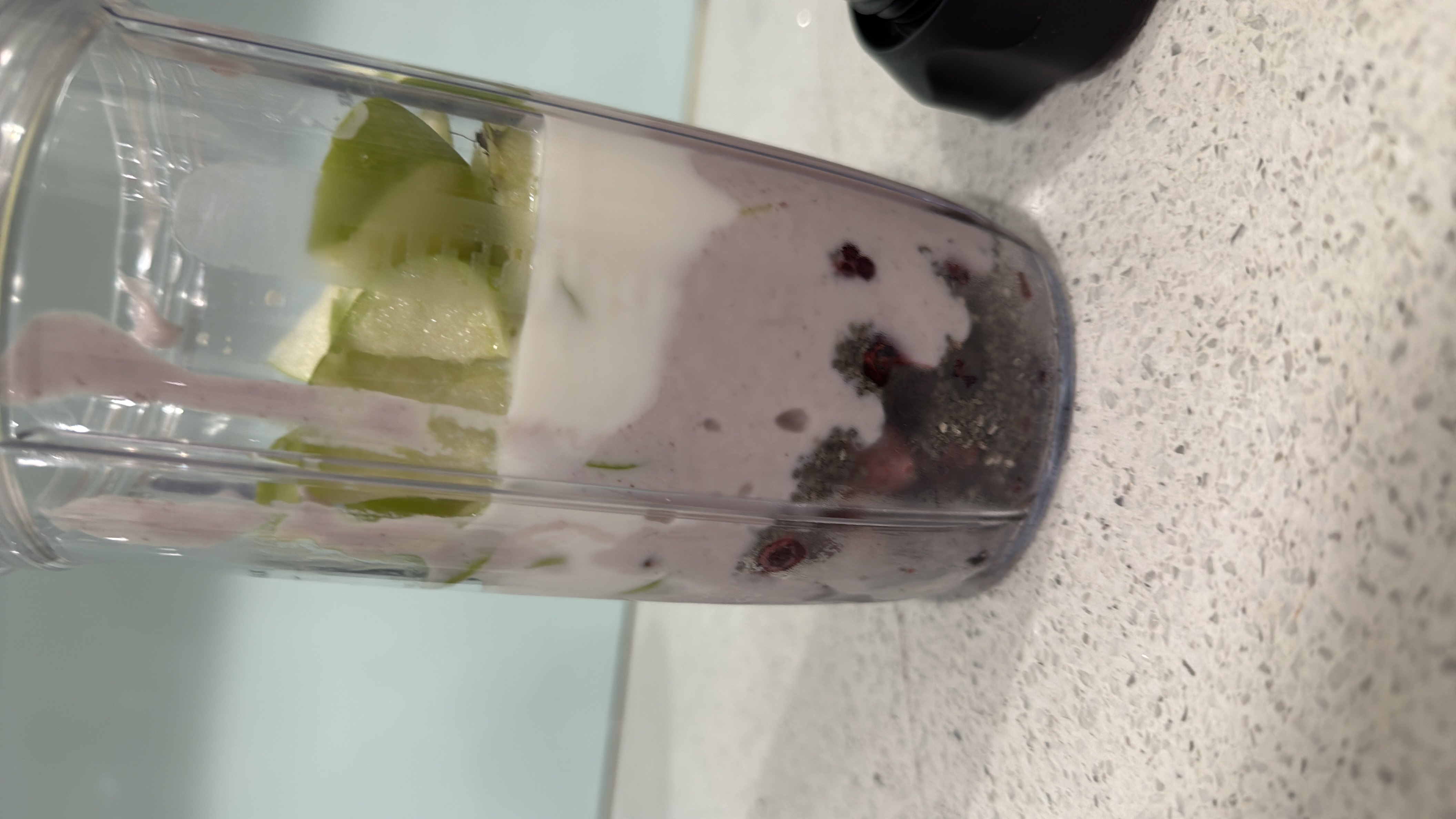 A nutritious smoothie made with blueberries, green apple, yogurt, and chia seeds, providing a balanced mix of protein, carbs, and fats.