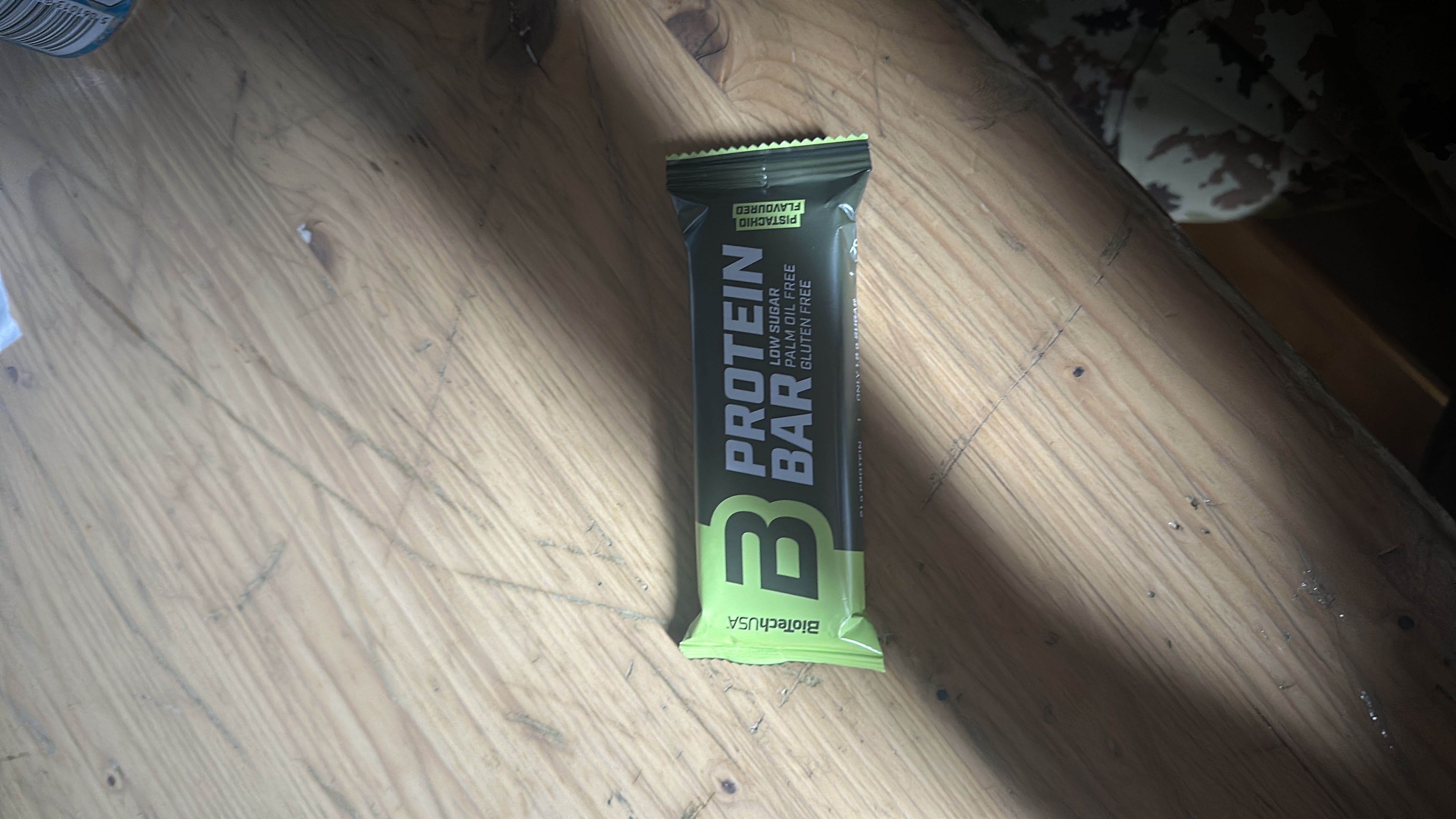 A pistachio-flavored protein bar with low sugar, palm oil-free, and gluten-free properties, providing a balanced nutritional profile.