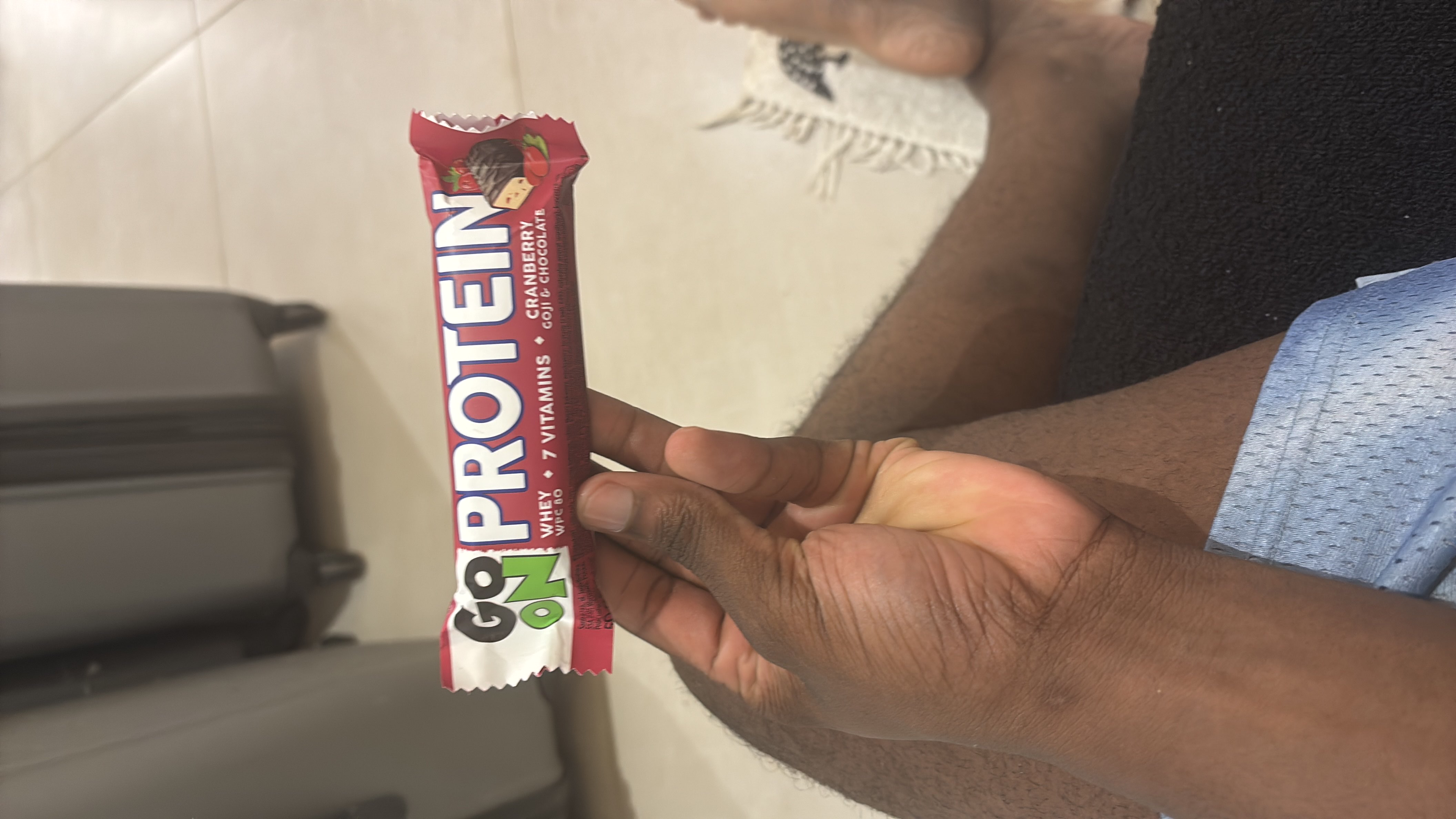 A protein bar containing whey, 7 vitamins, cranberry, goji, and chocolate, designed for a nutritious snack.