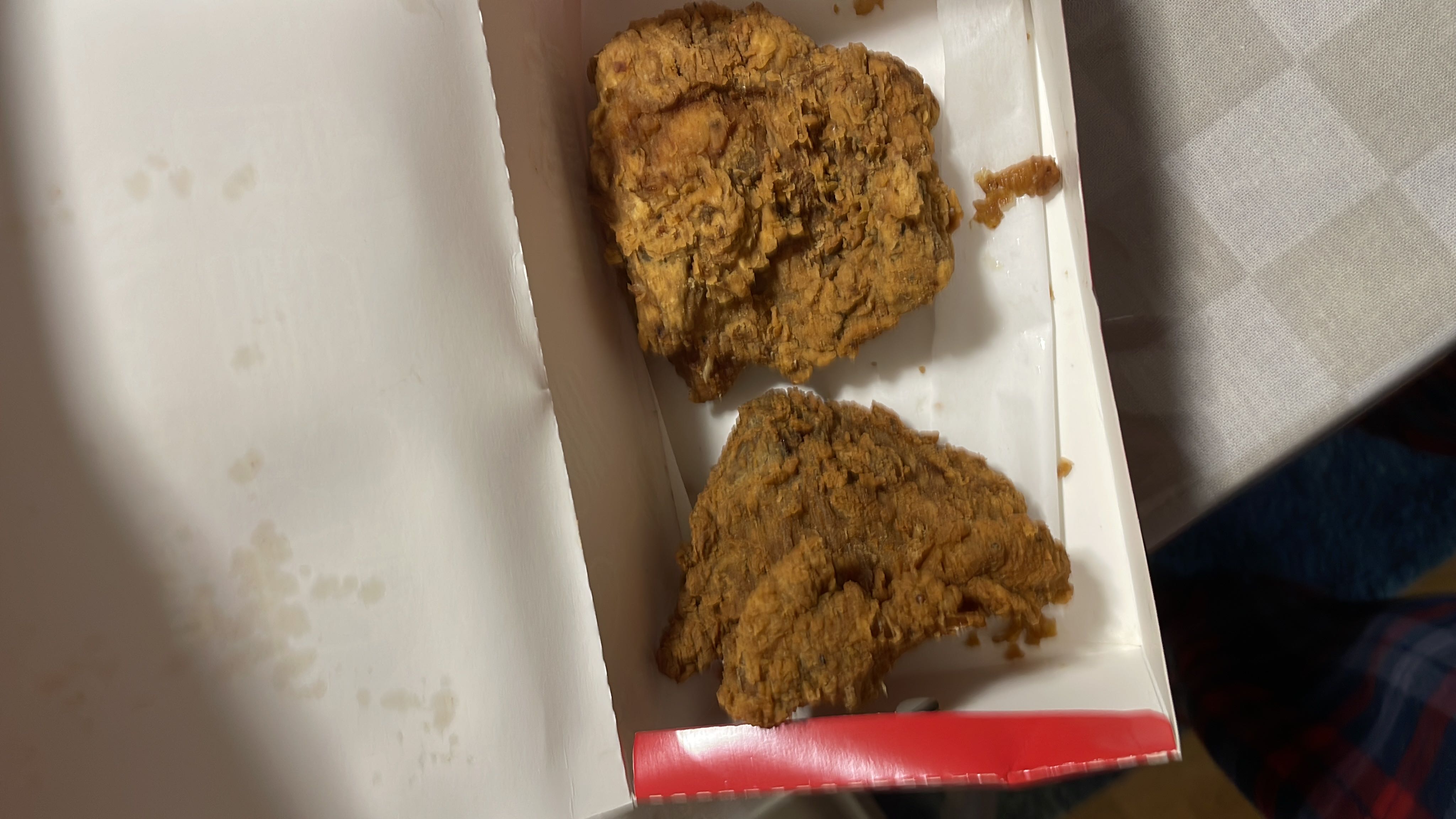 The image shows two pieces of fried chicken, which are high in calories, protein, and fats, with moderate carbohydrate content.