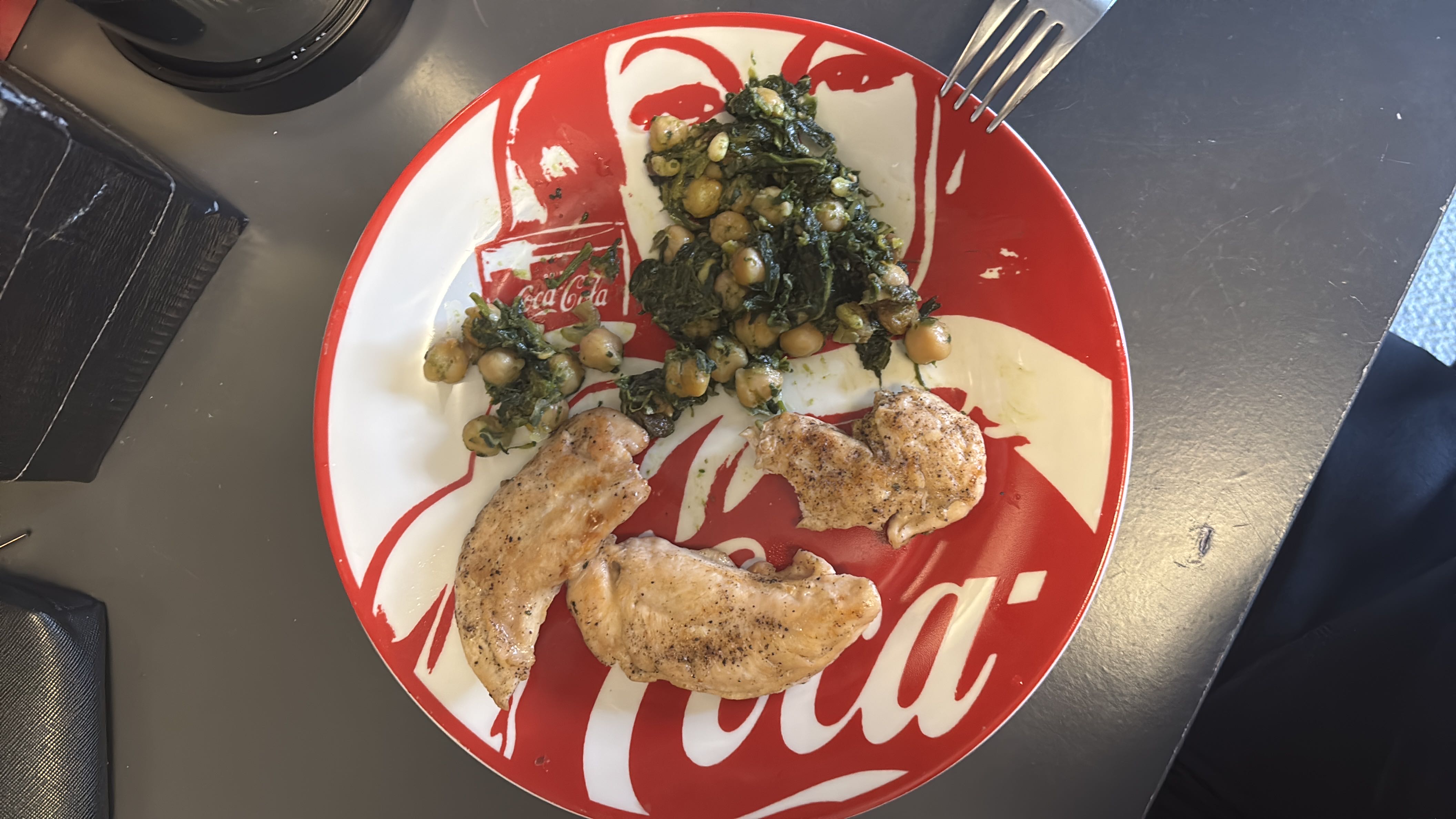A balanced meal consisting of grilled chicken breast, chickpeas, and sautéed spinach, providing a good source of protein and fiber.