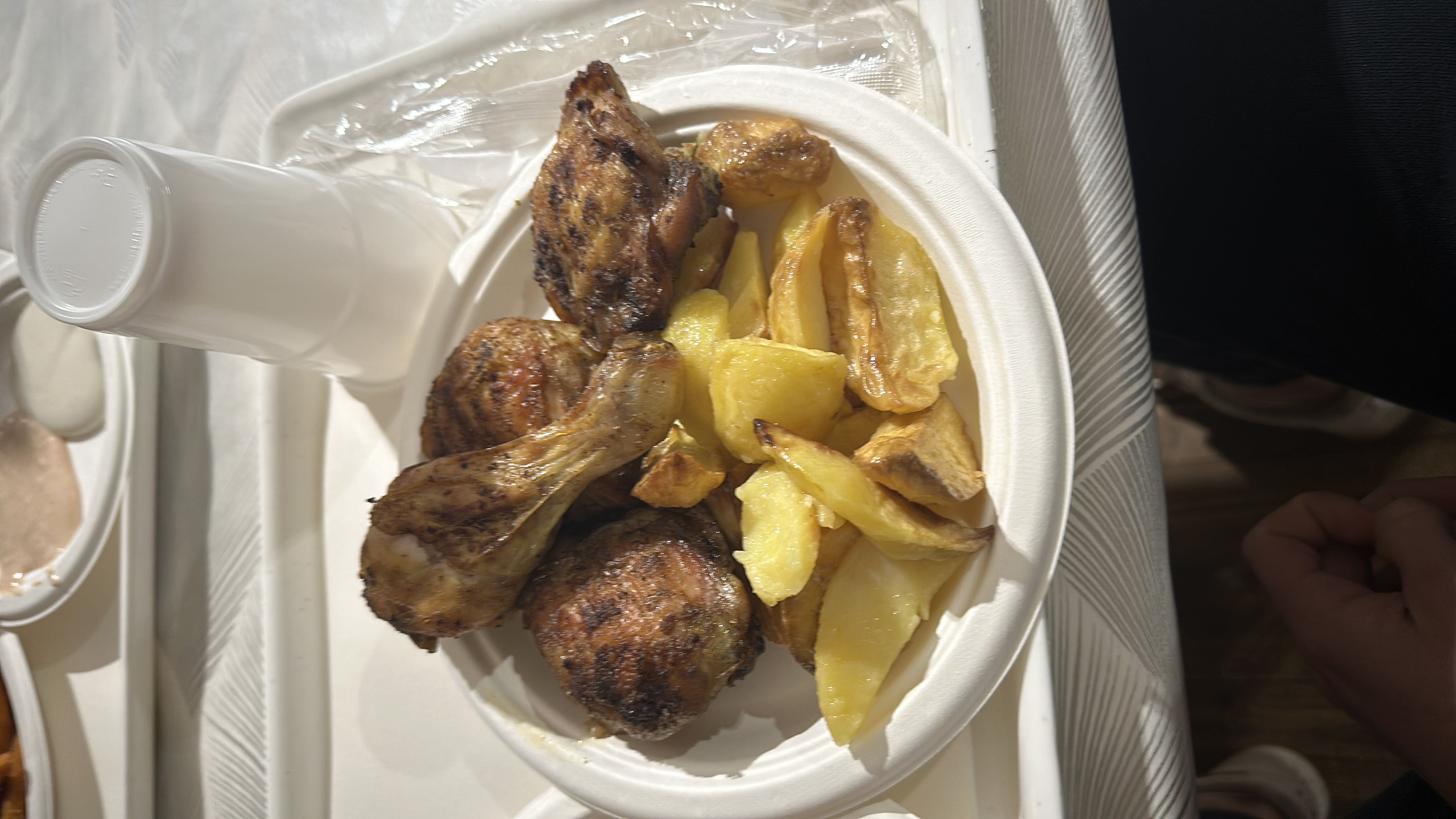 A plate of grilled chicken and potato wedges, providing a balanced mix of protein, carbs, and fats.