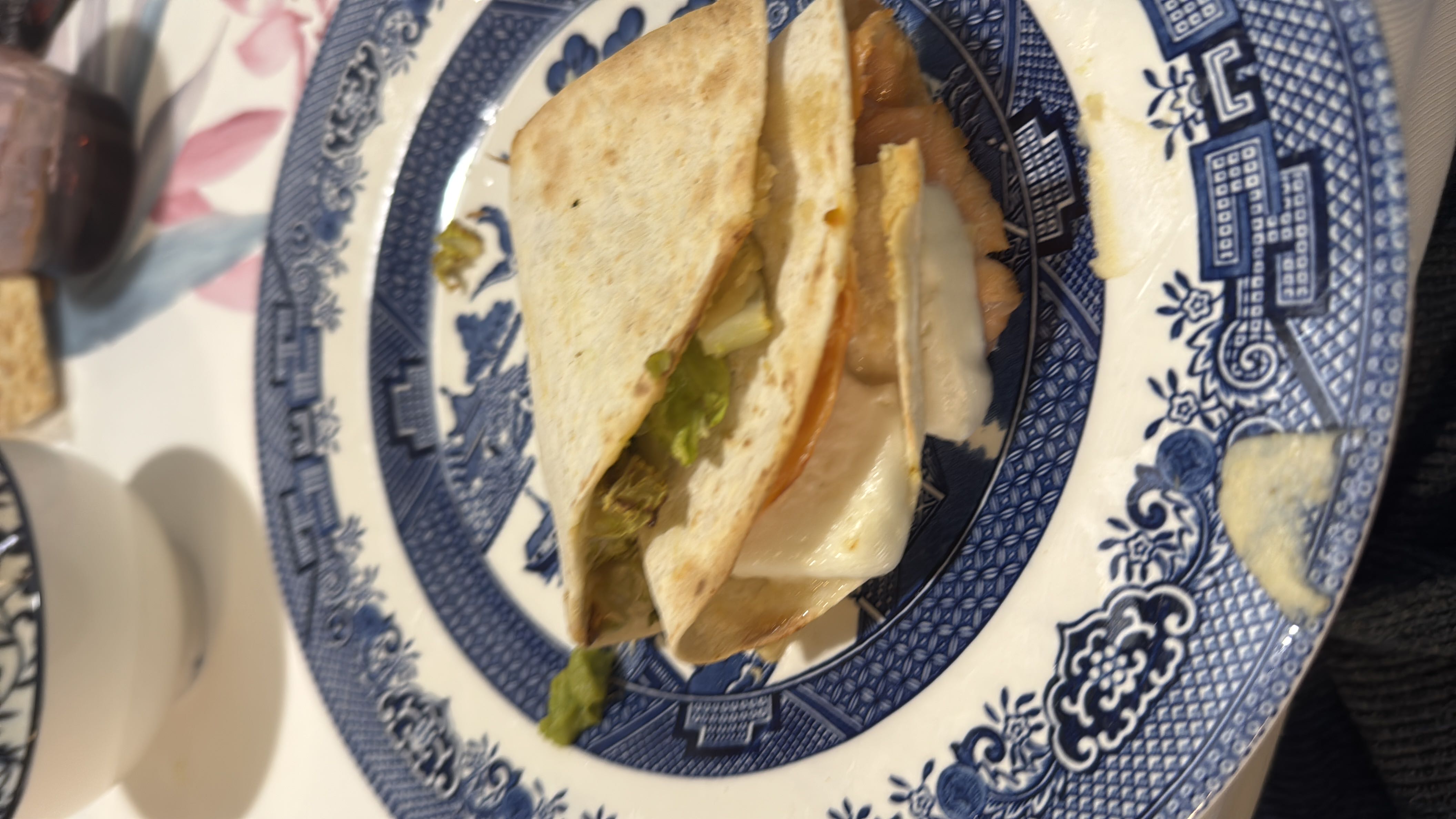 A folded tortilla filled with cheese, chicken, and lettuce, providing a balanced mix of protein, carbs, and fats.