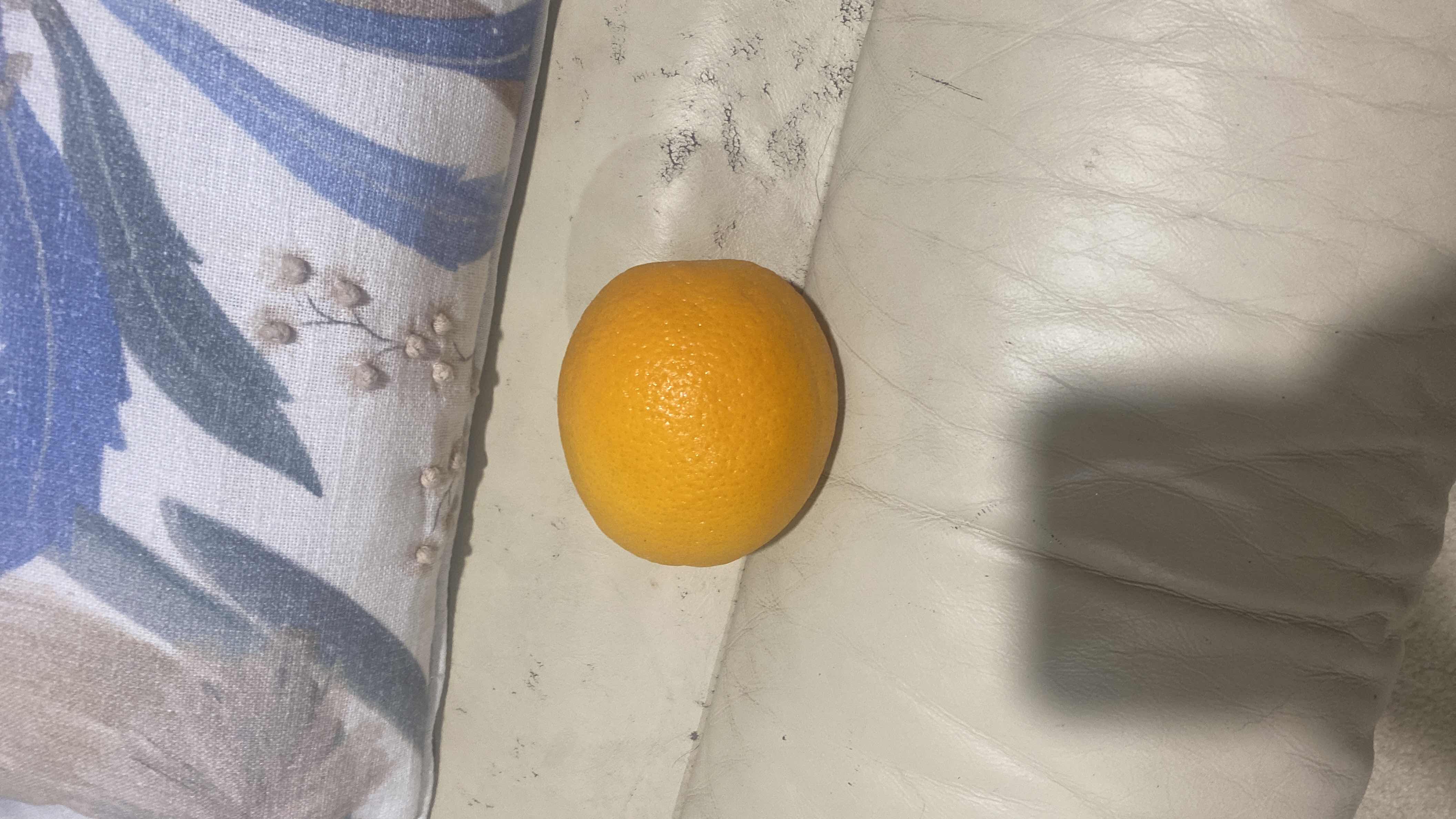 The image shows an orange, a citrus fruit rich in vitamin C and low in calories, making it a healthy snack option.