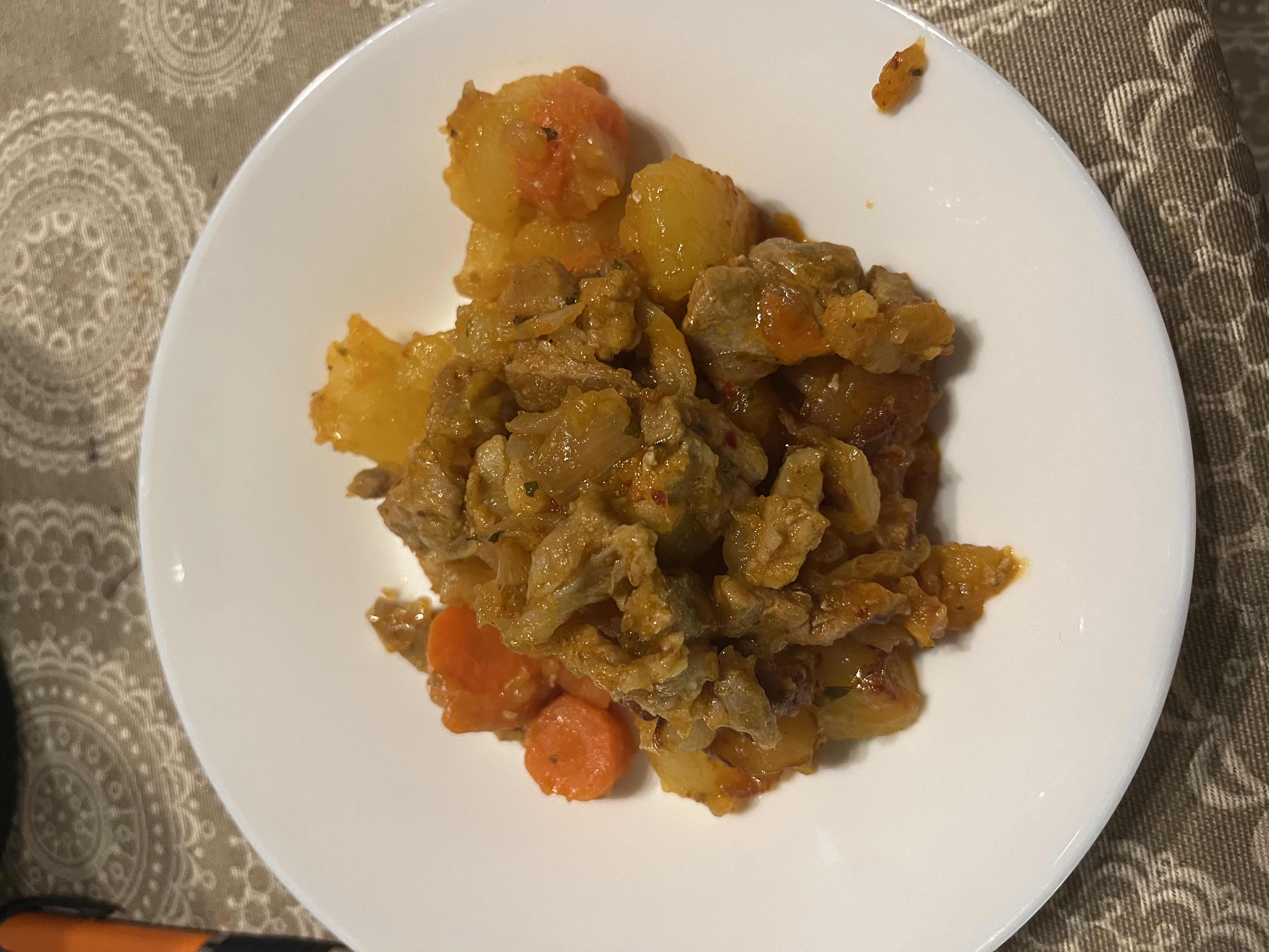 A hearty dish consisting of beef, potatoes, carrots, and onions, cooked with spices for a flavorful and balanced meal.