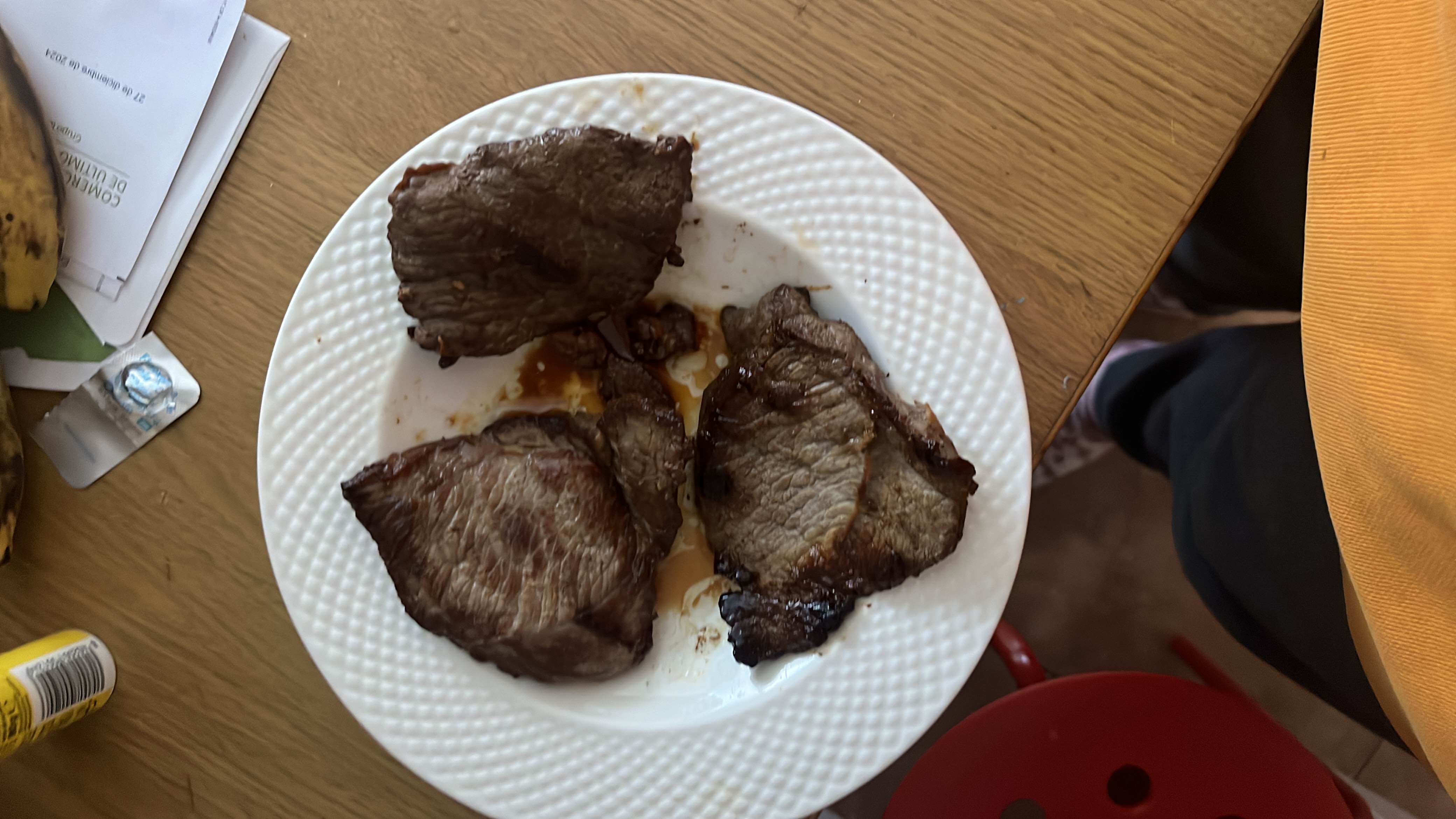 The image shows a plate of cooked beef steaks, which are high in protein and fats with no carbohydrates.