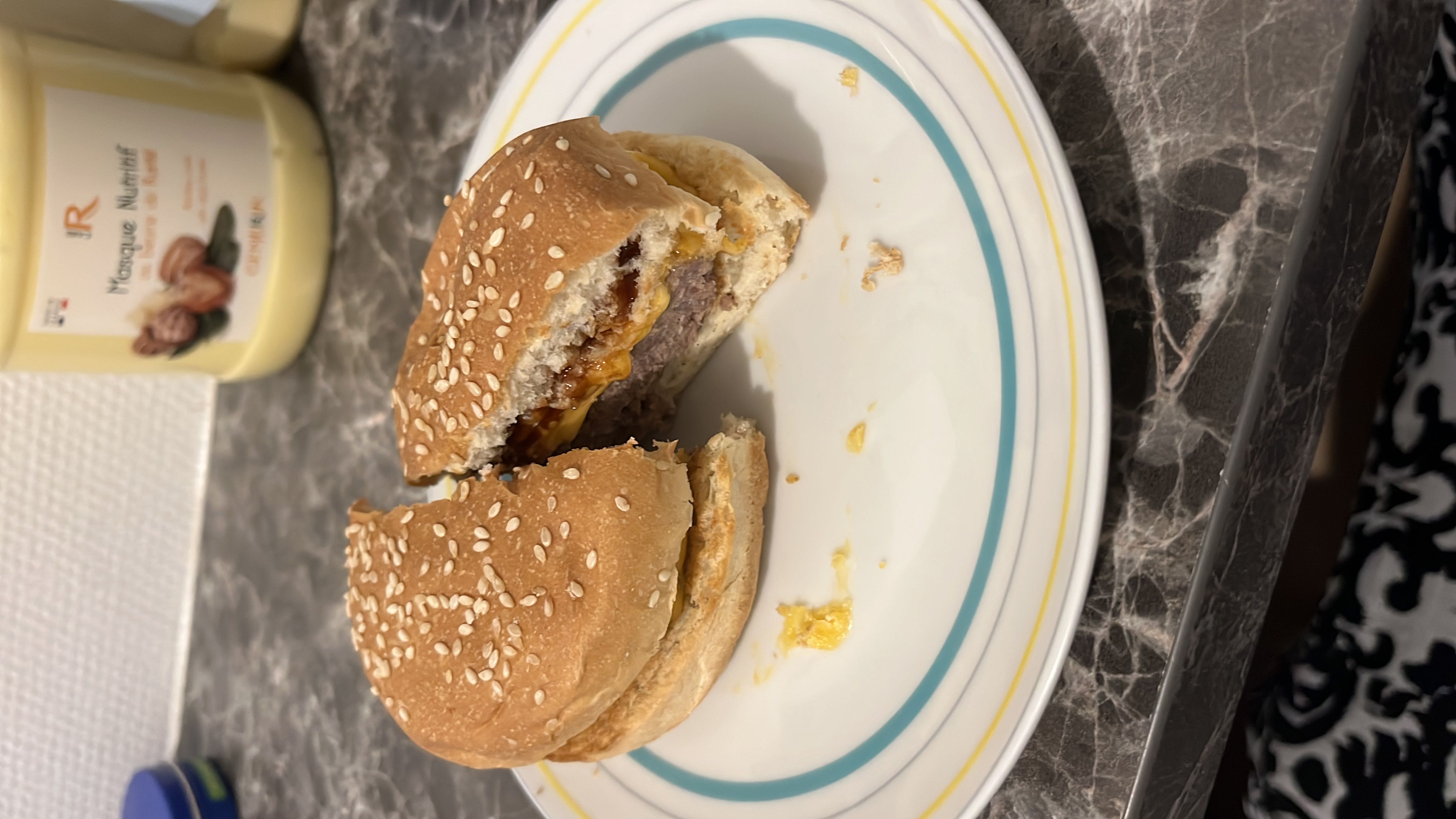 A cheeseburger with a sesame seed bun, beef patty, and cheese.