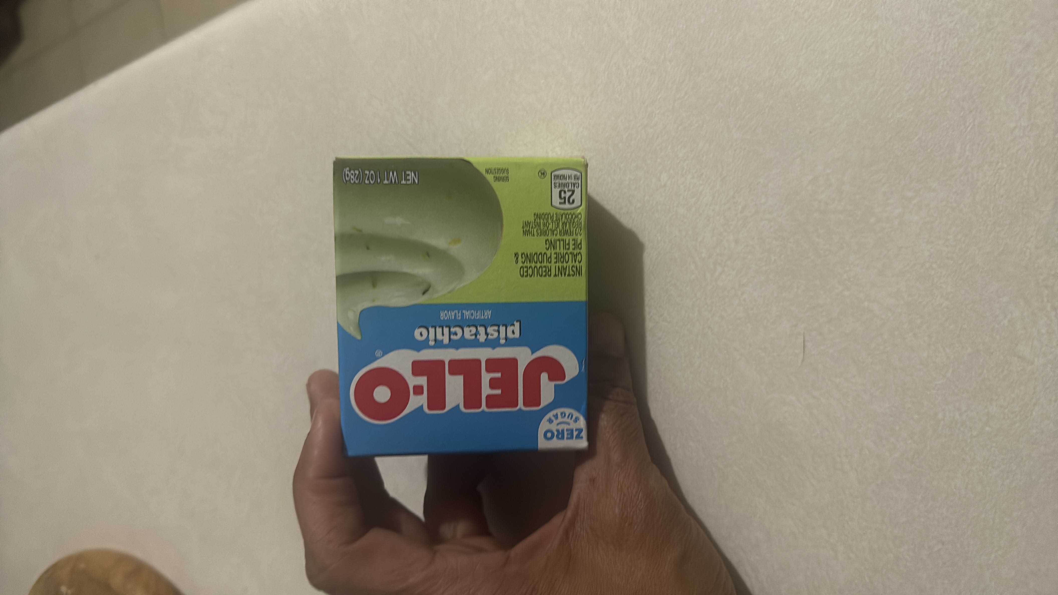 This is a box of Jell-O pistachio-flavored instant pudding mix with 25 calories per serving, zero sugar, and reduced calorie content.