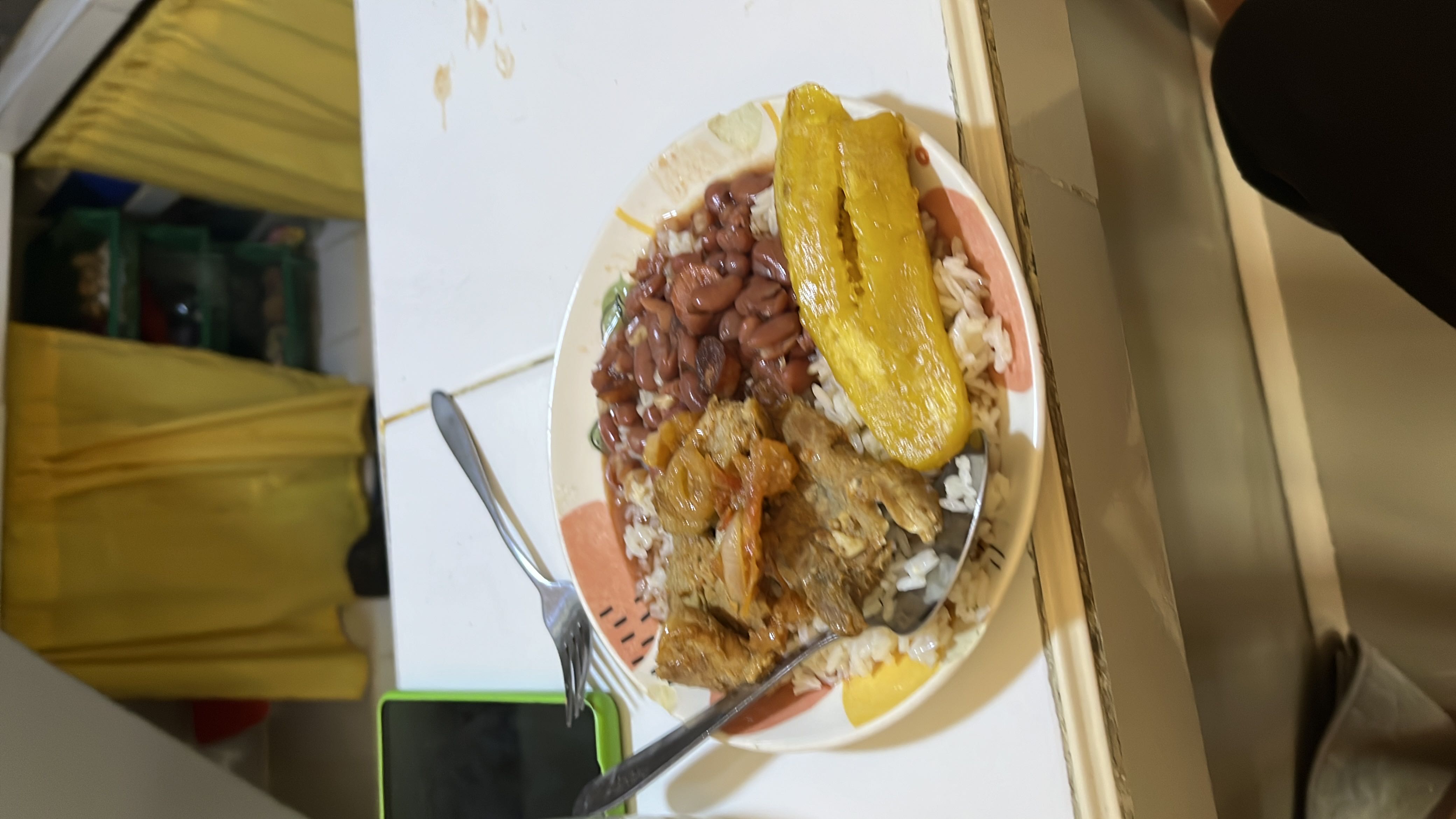 A balanced meal consisting of rice, beans, plantain, and meat, providing a good mix of protein, carbohydrates, and fats.