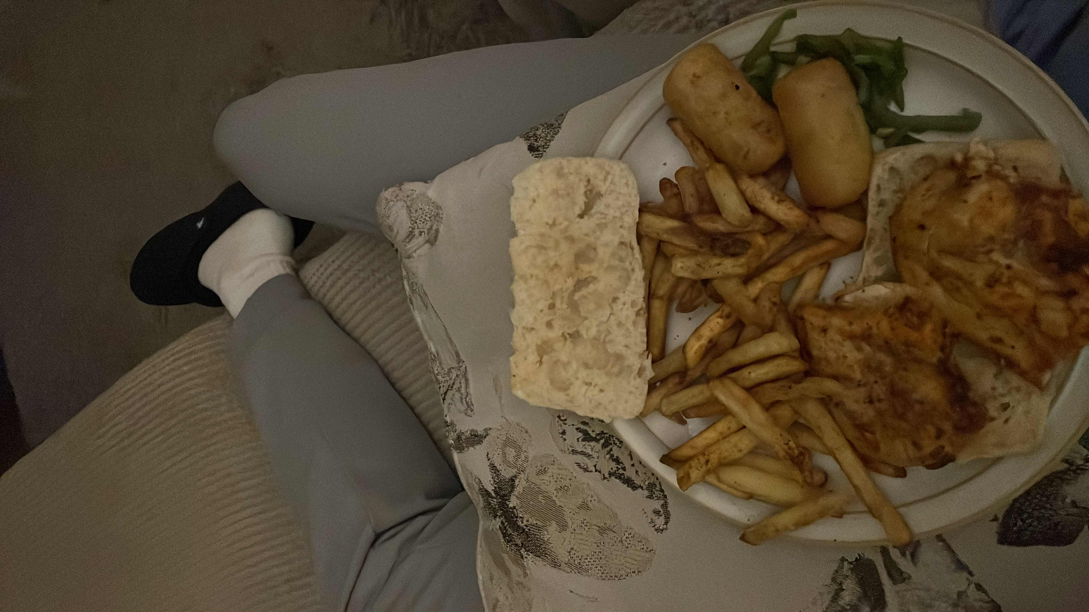 A meal consisting of French fries, grilled chicken, bread, and vegetables, providing a balanced mix of protein, carbs, and fats.