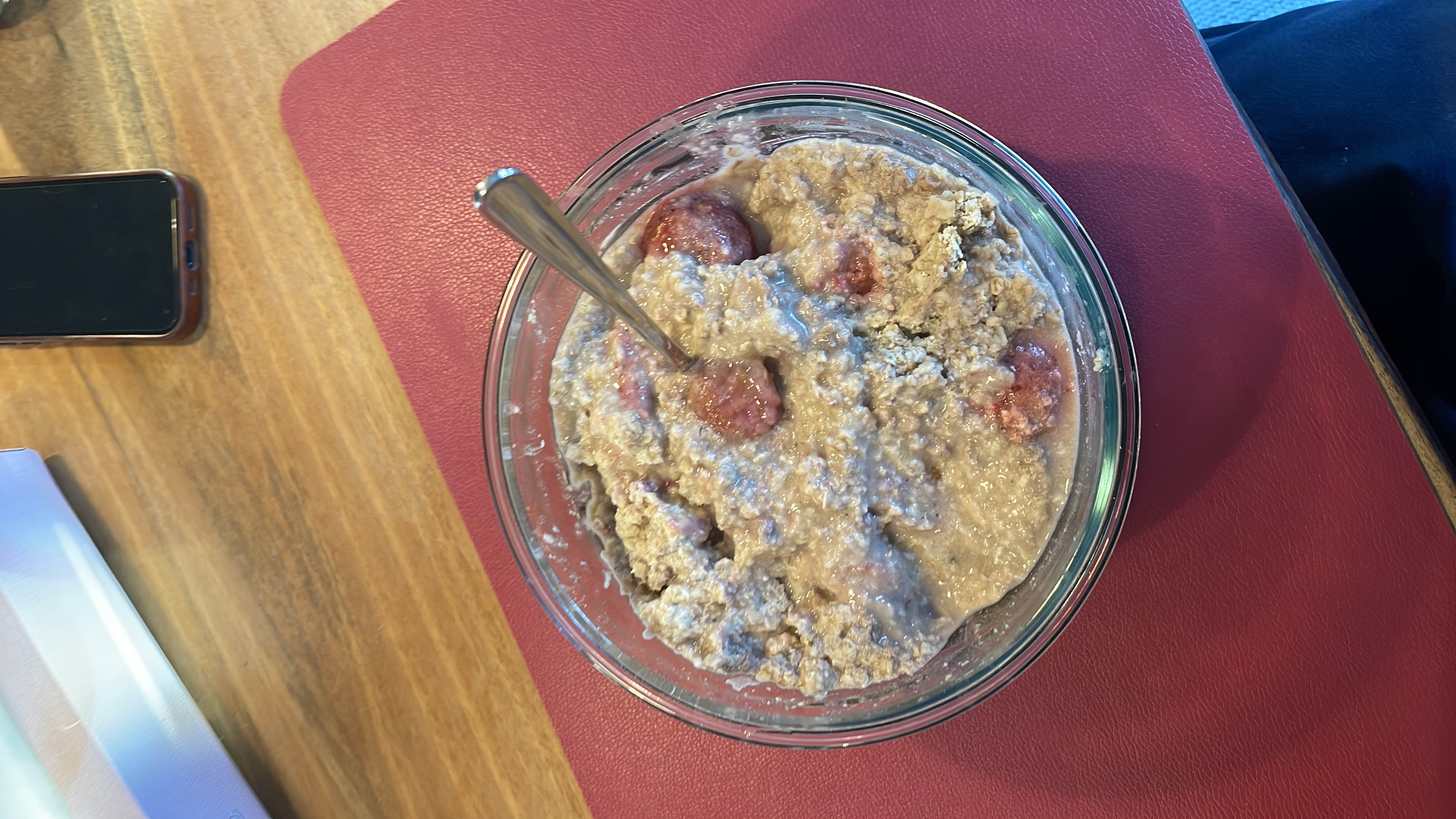 A bowl of oatmeal with oats, strawberries, protein powder, and water, providing a balanced mix of carbs and protein.