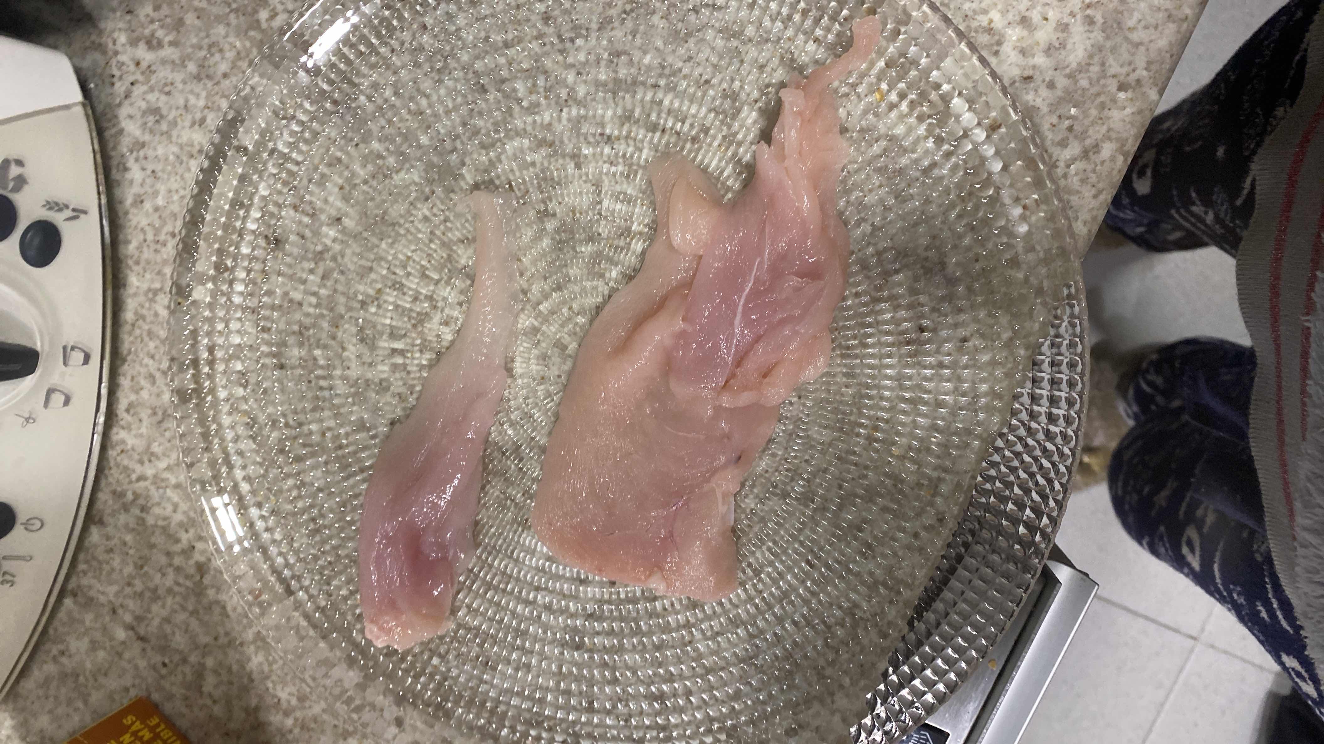The image shows raw chicken breast, a lean protein source with minimal fat and no carbohydrates.