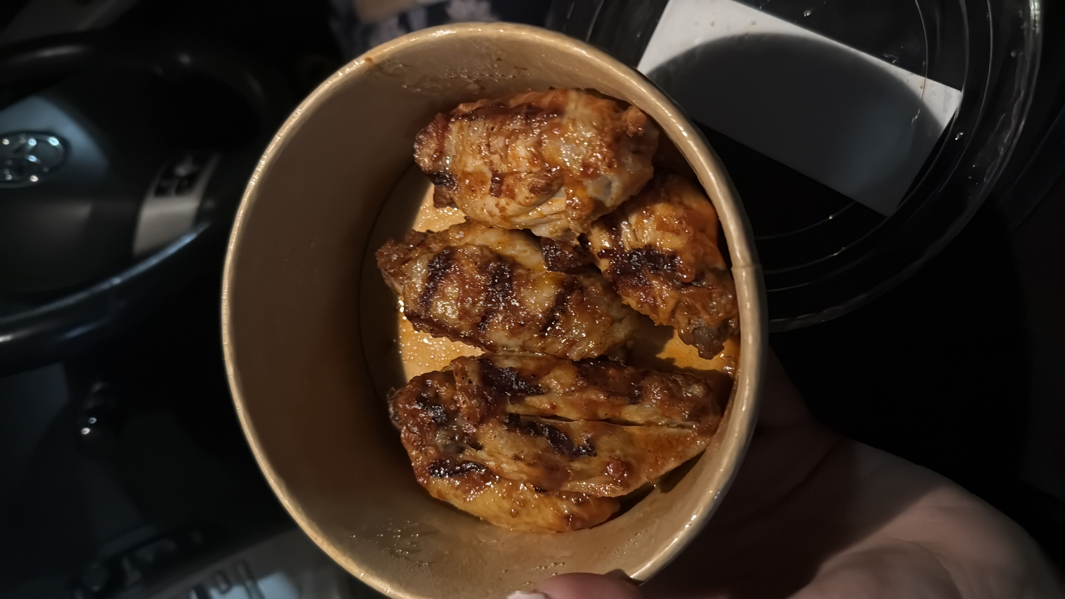 Grilled chicken wings served in a bowl, likely seasoned with spices and a light sauce.