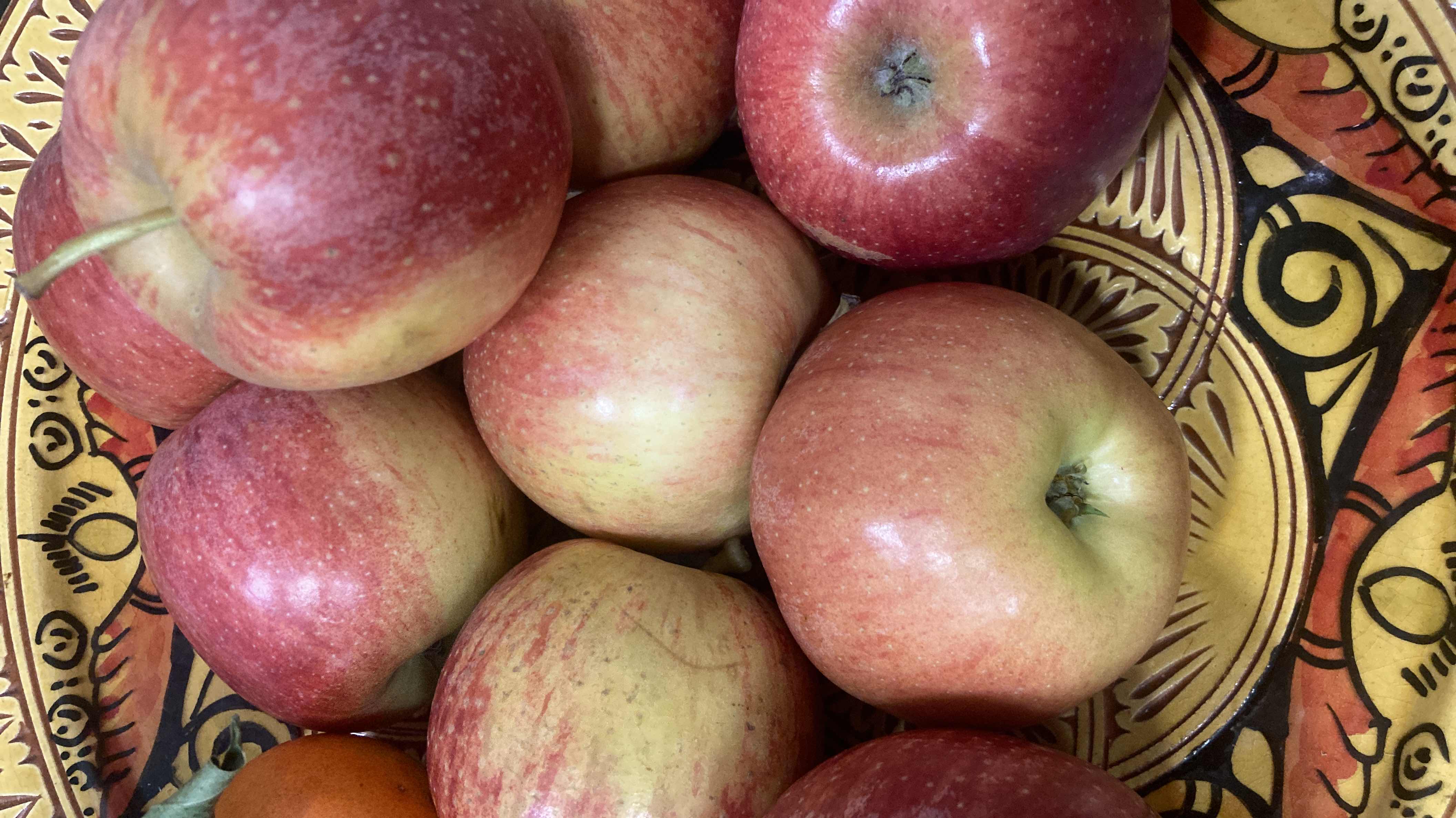 The image shows a bowl of fresh apples, which are a nutritious fruit rich in carbohydrates and low in fats and protein.