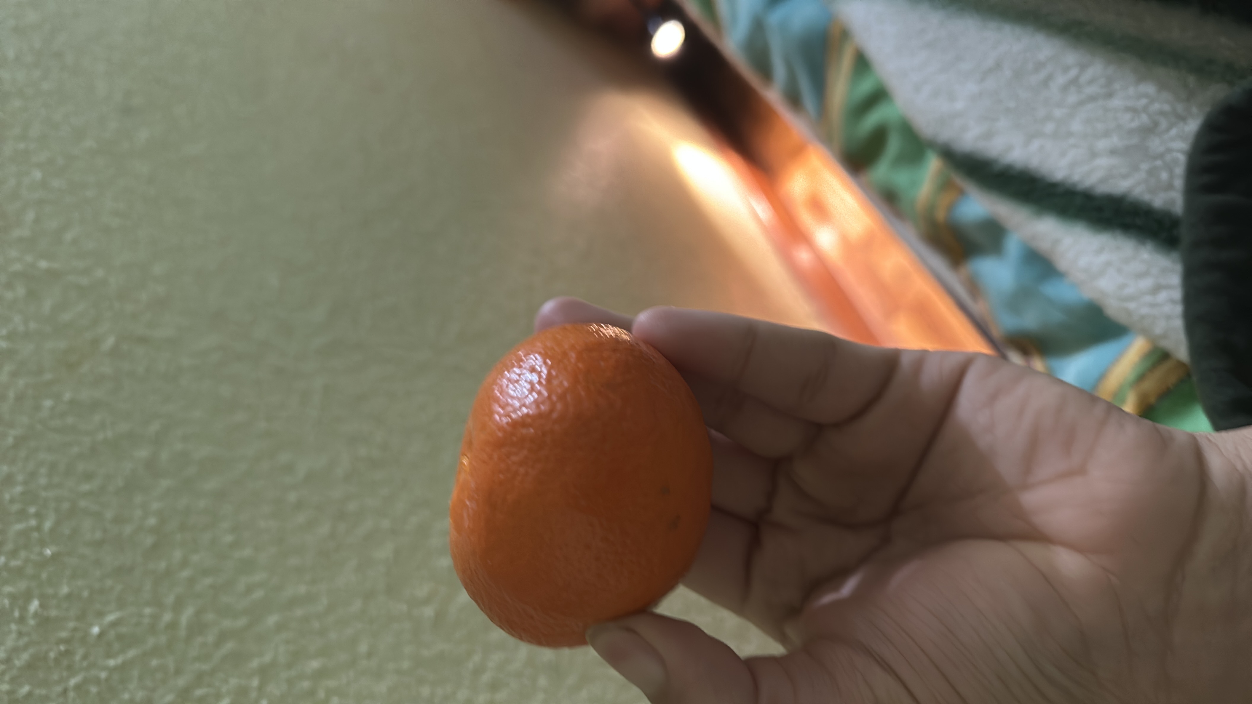 A small mandarin orange, low in calories, rich in vitamin C, and a healthy snack option.