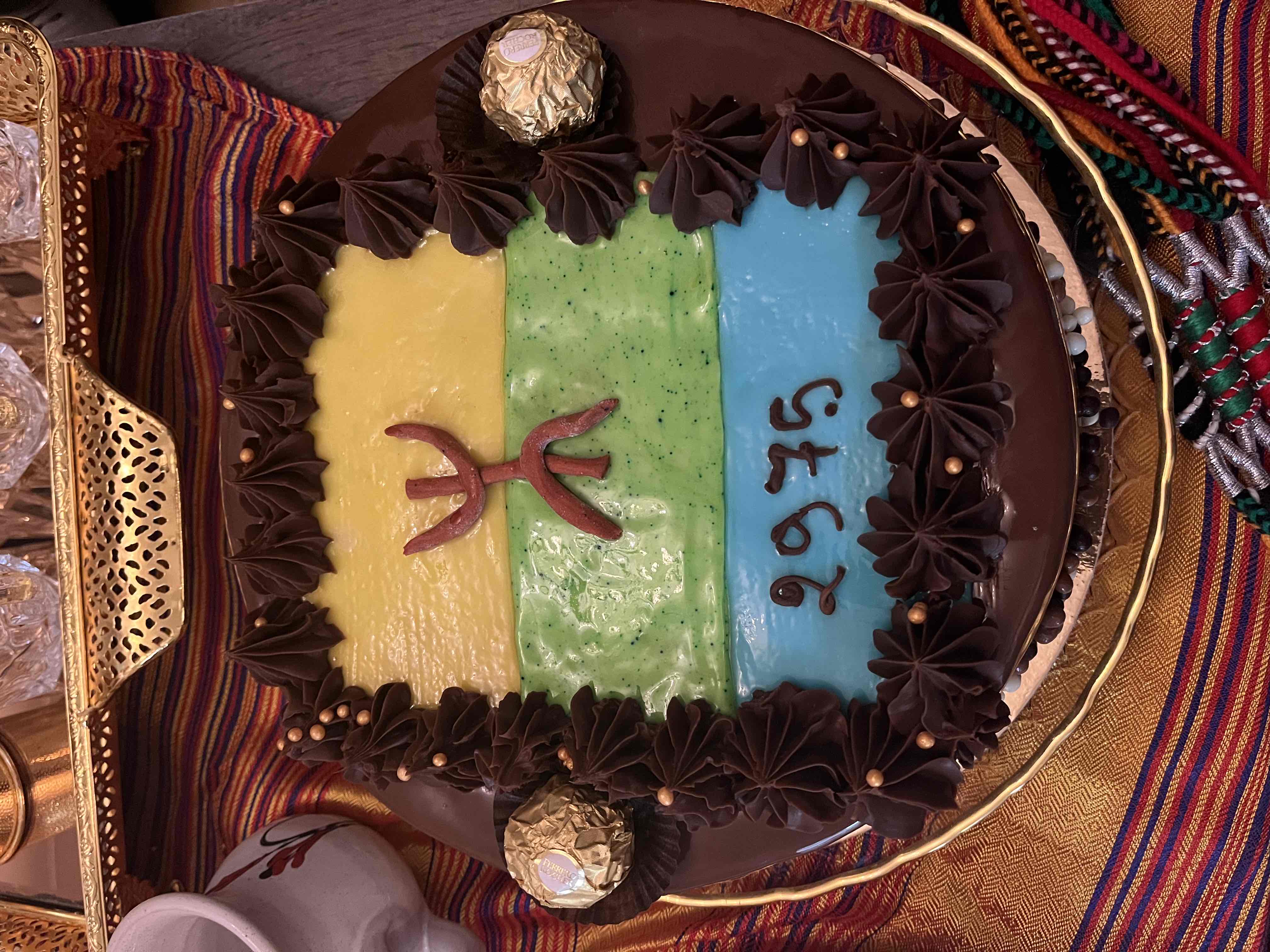A colorful cake with chocolate decorations and a high calorie count, suitable for celebrations.
