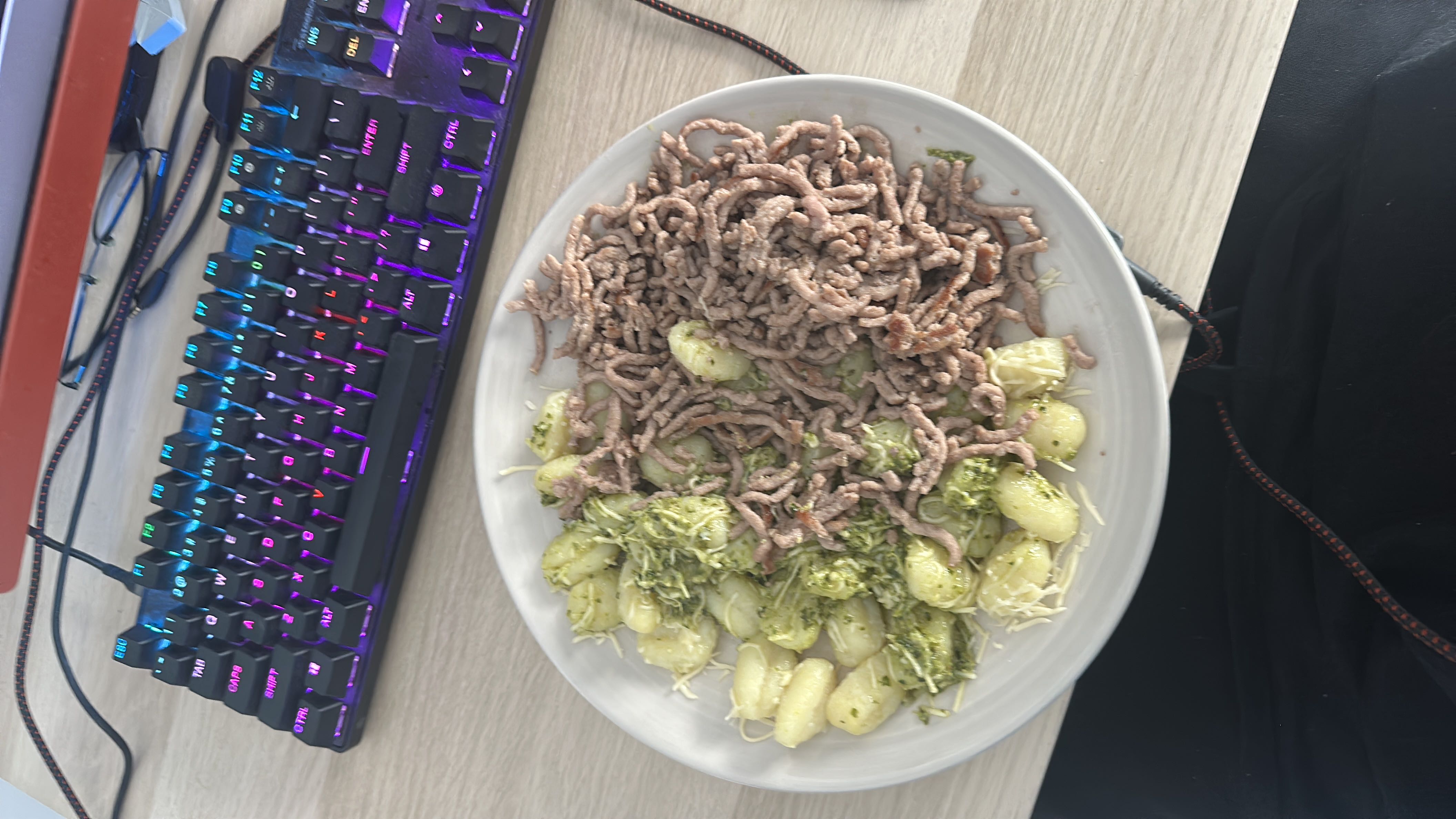 A plate of gnocchi with pesto sauce and ground meat, providing a balanced mix of protein, carbs, and fats.