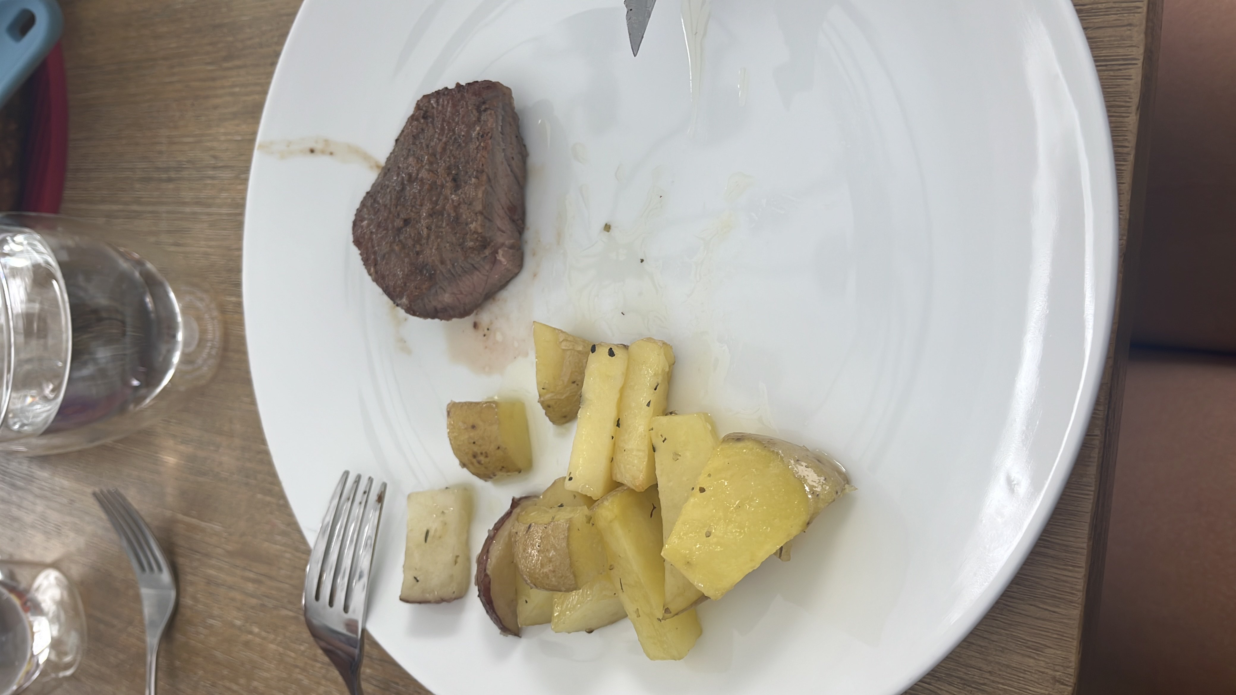 A plate containing a portion of steak and roasted potatoes, providing a balanced mix of protein, carbs, and fats.