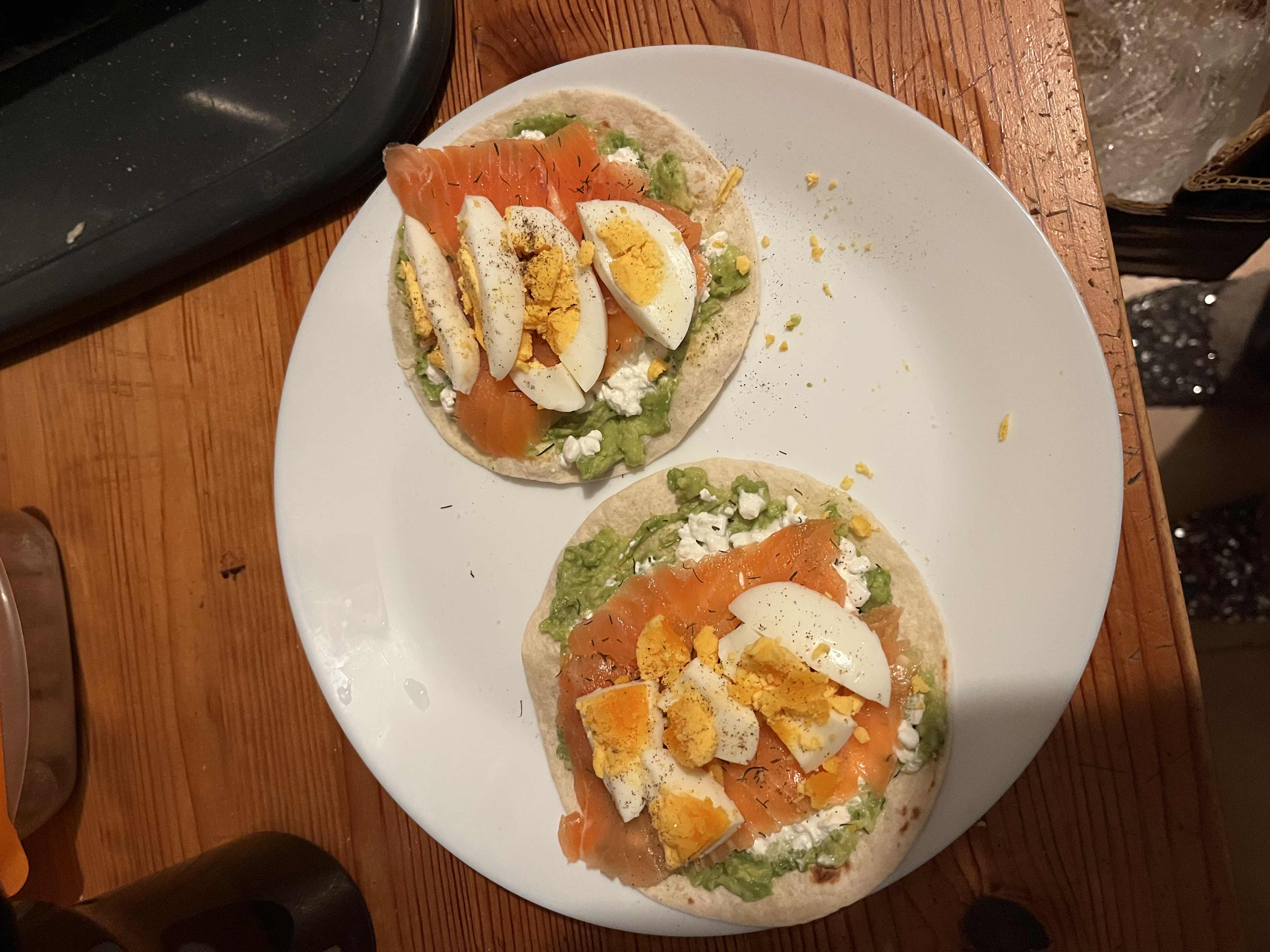 This dish consists of tortillas topped with avocado, cottage cheese, smoked salmon, and boiled eggs, providing a balanced mix of protein, healthy fats, and carbohydrates.