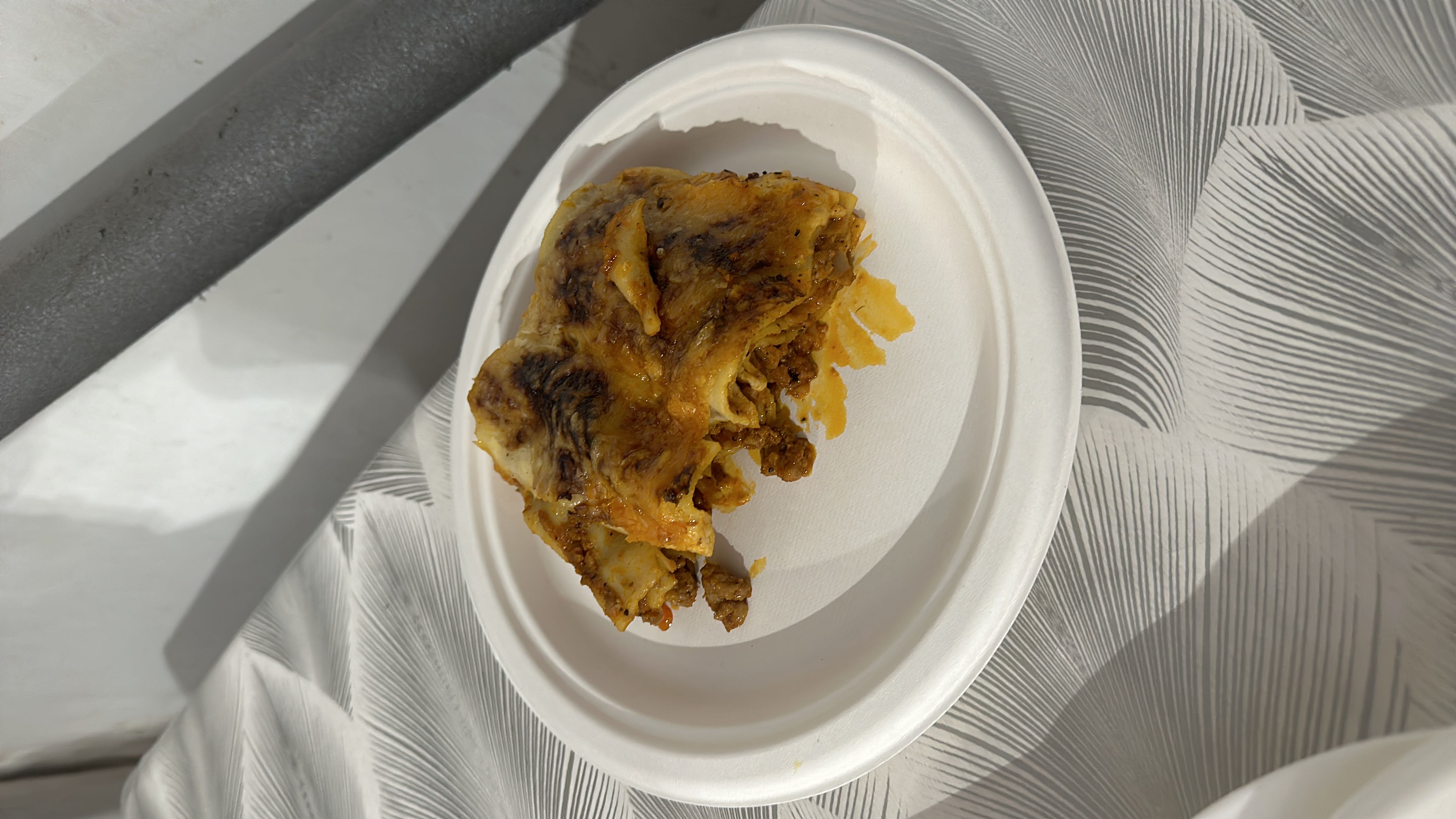 A serving of lasagna with layers of pasta, ground beef, and cheese, baked to a golden brown.