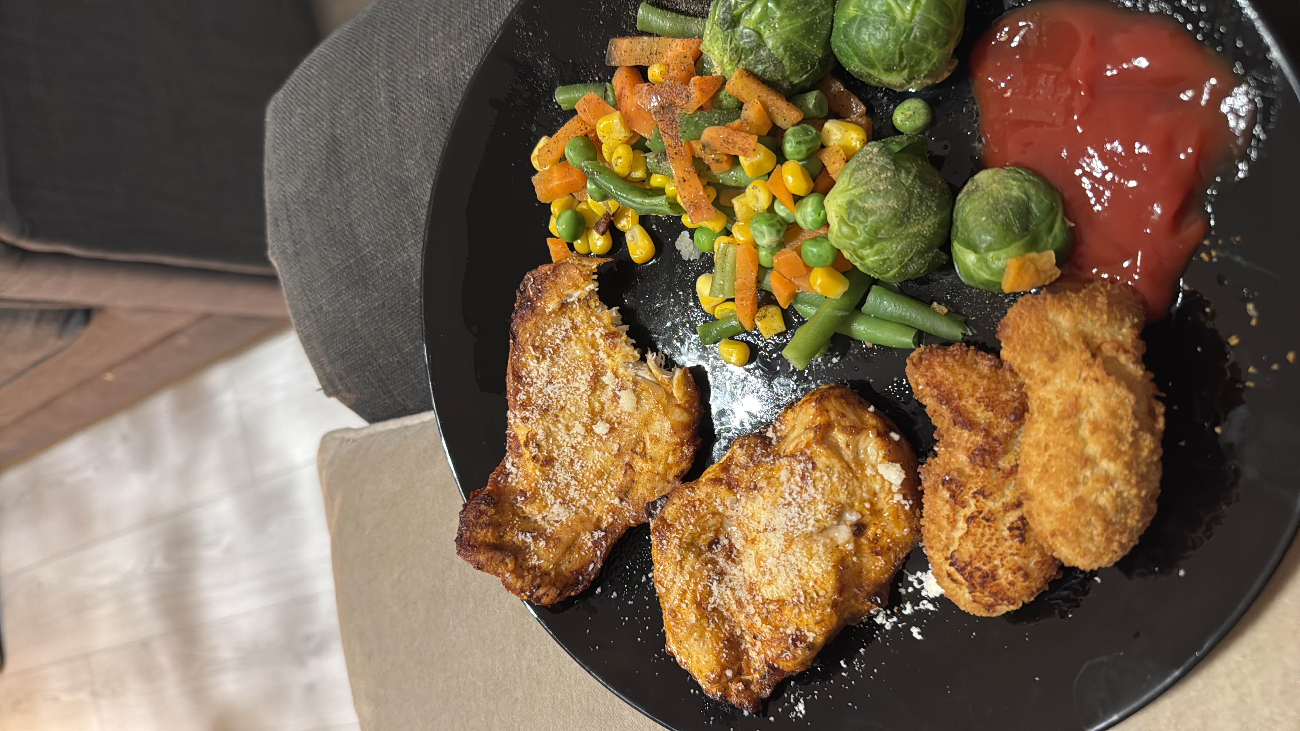 A balanced meal consisting of grilled chicken, mixed vegetables, breaded nuggets, and ketchup.