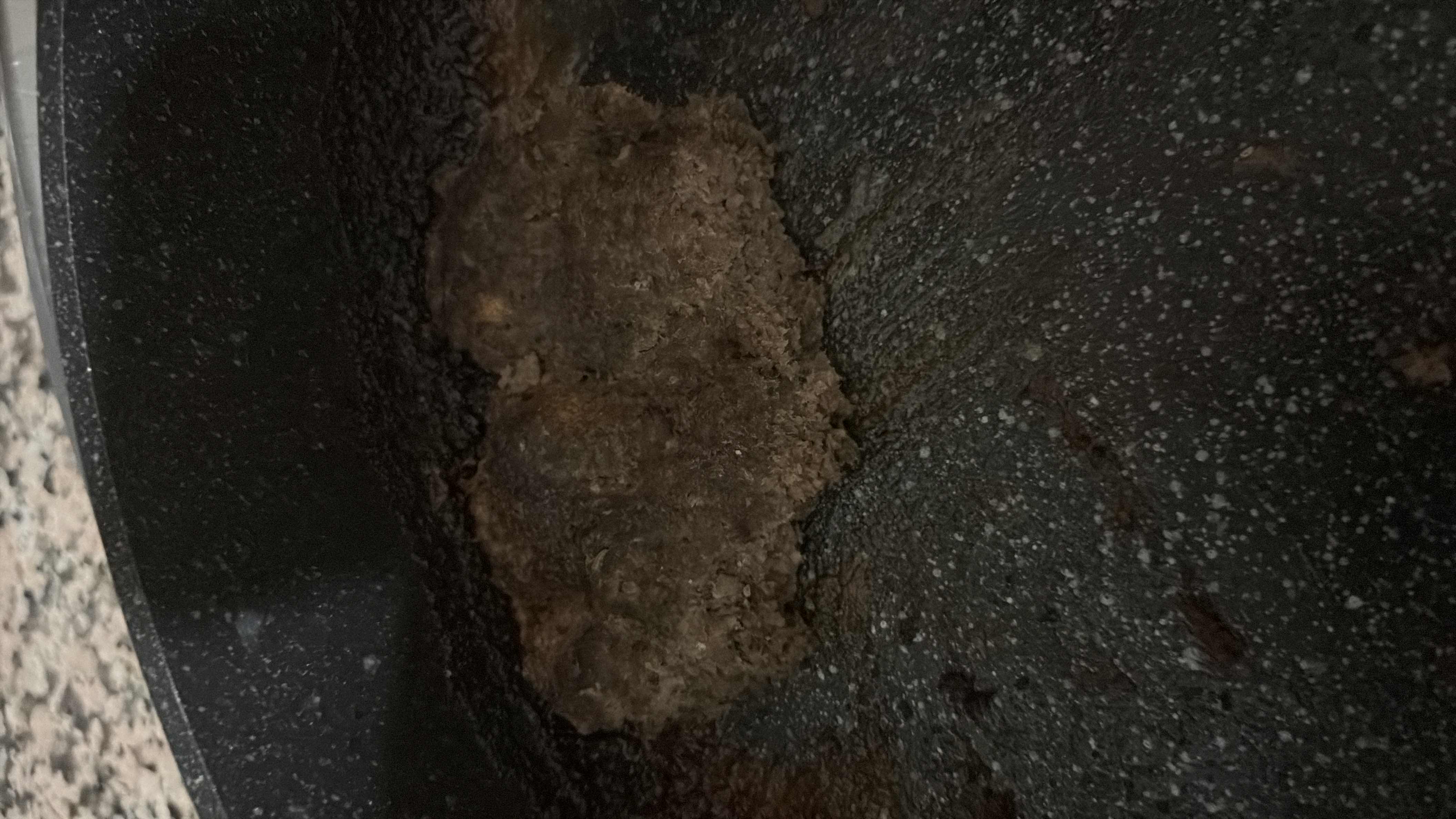 The image depicts a burnt or overcooked food item in a pan, making it difficult to determine its nutritional content.