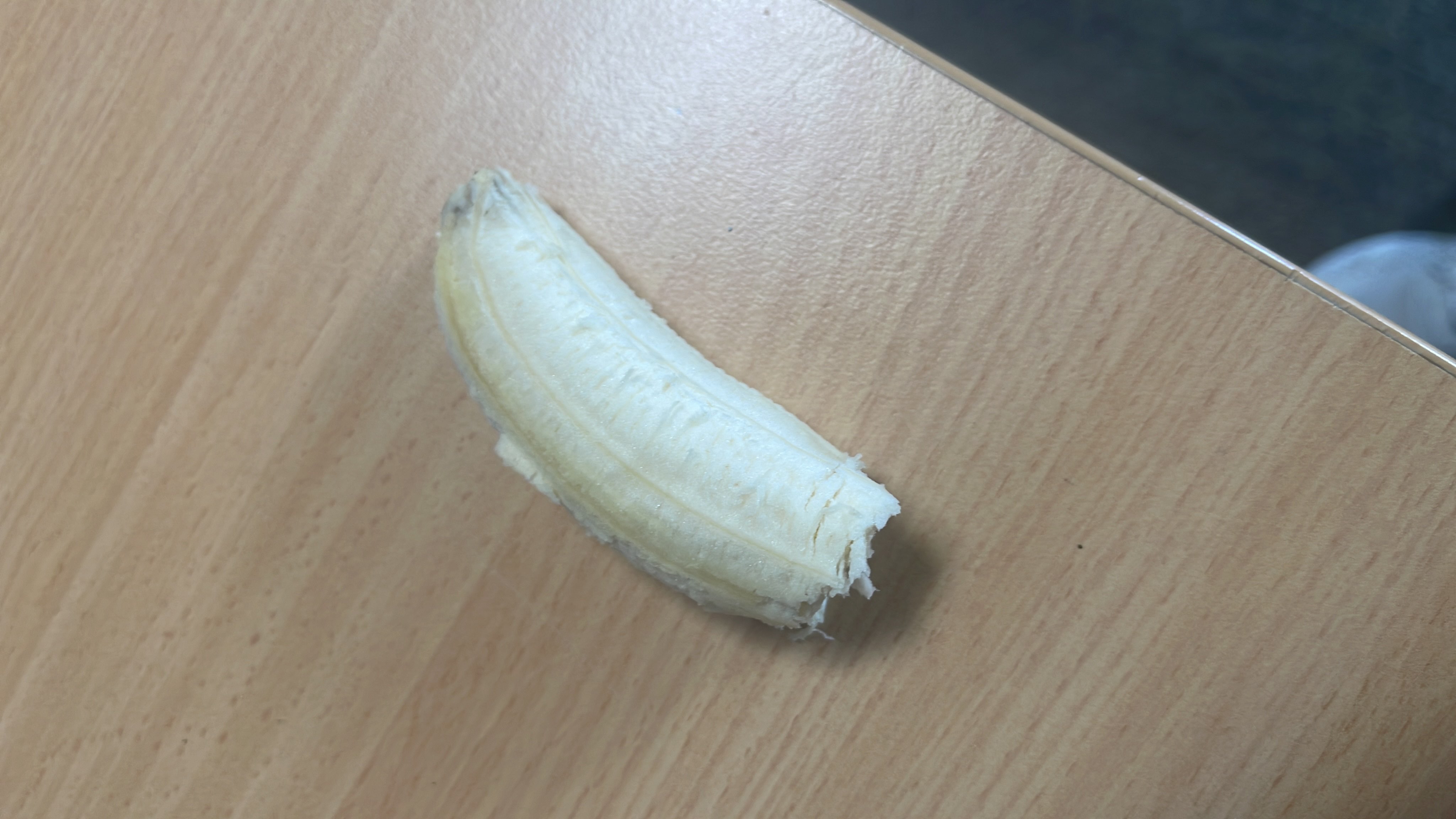 The image shows a partially peeled banana, which is a nutritious fruit rich in carbohydrates and low in fats.