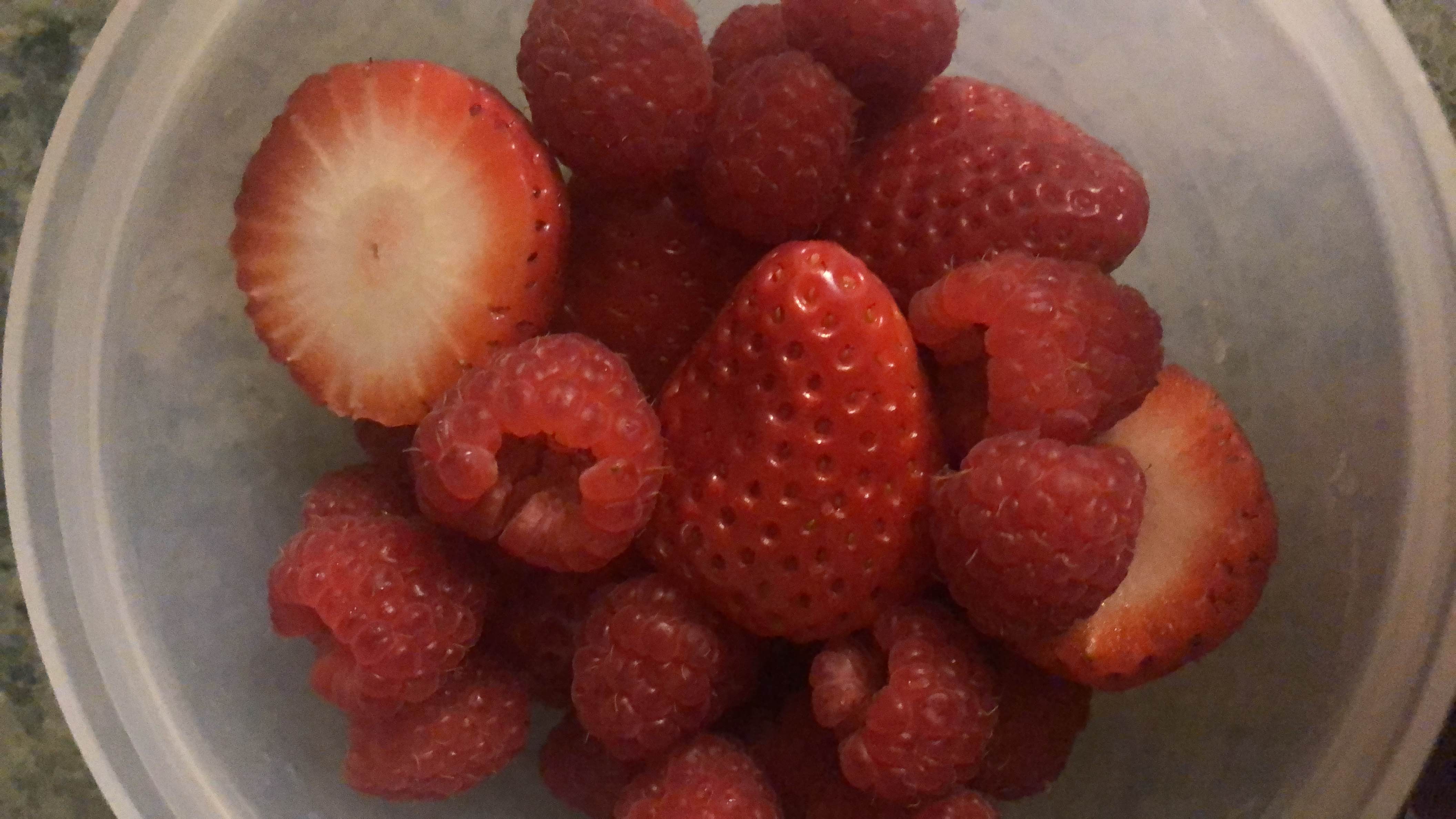 A bowl of fresh strawberries and raspberries, low in calories and rich in vitamins.