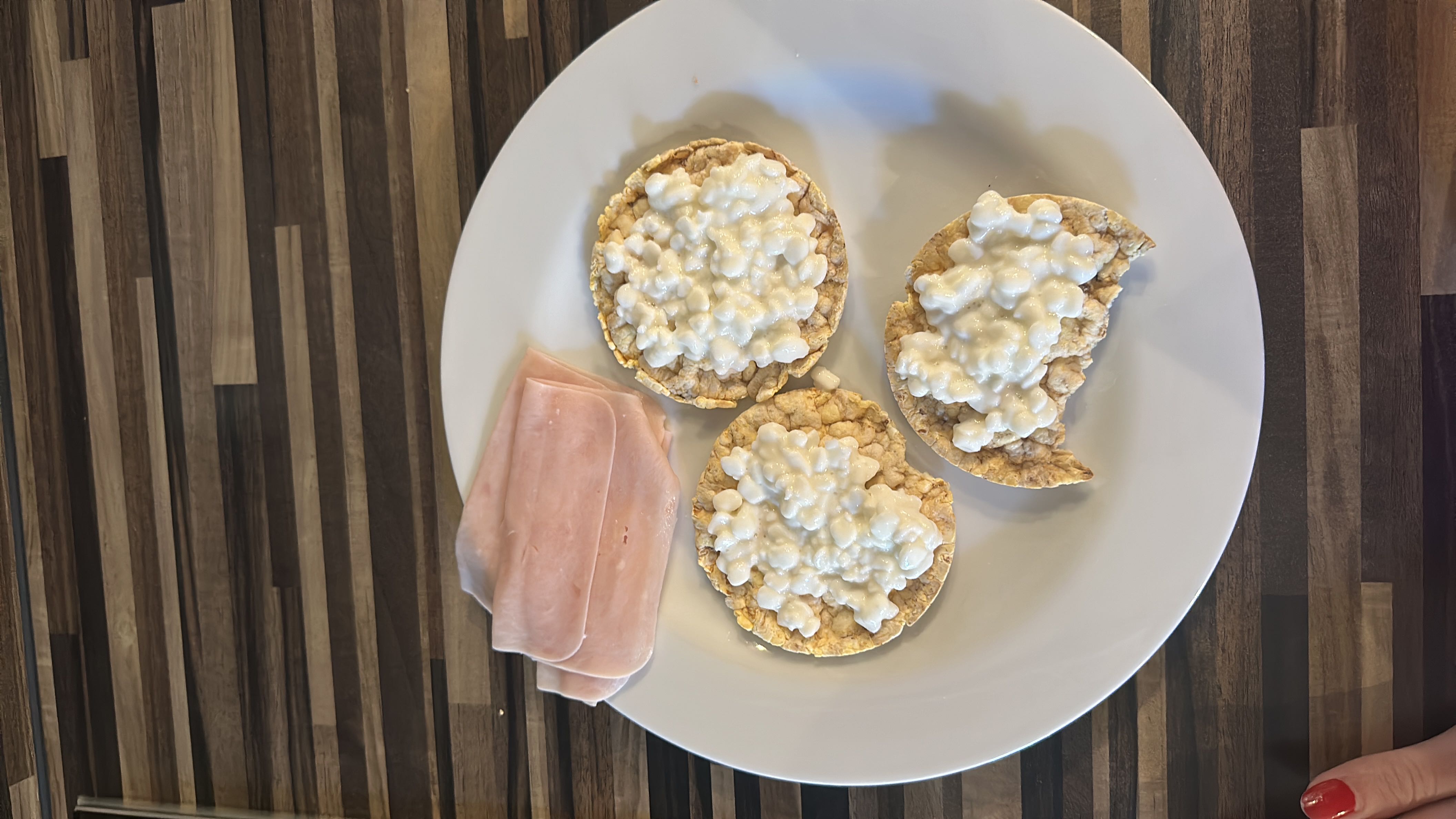 A light meal consisting of rice cakes topped with cottage cheese and served with turkey slices, providing a balanced mix of protein and carbohydrates.