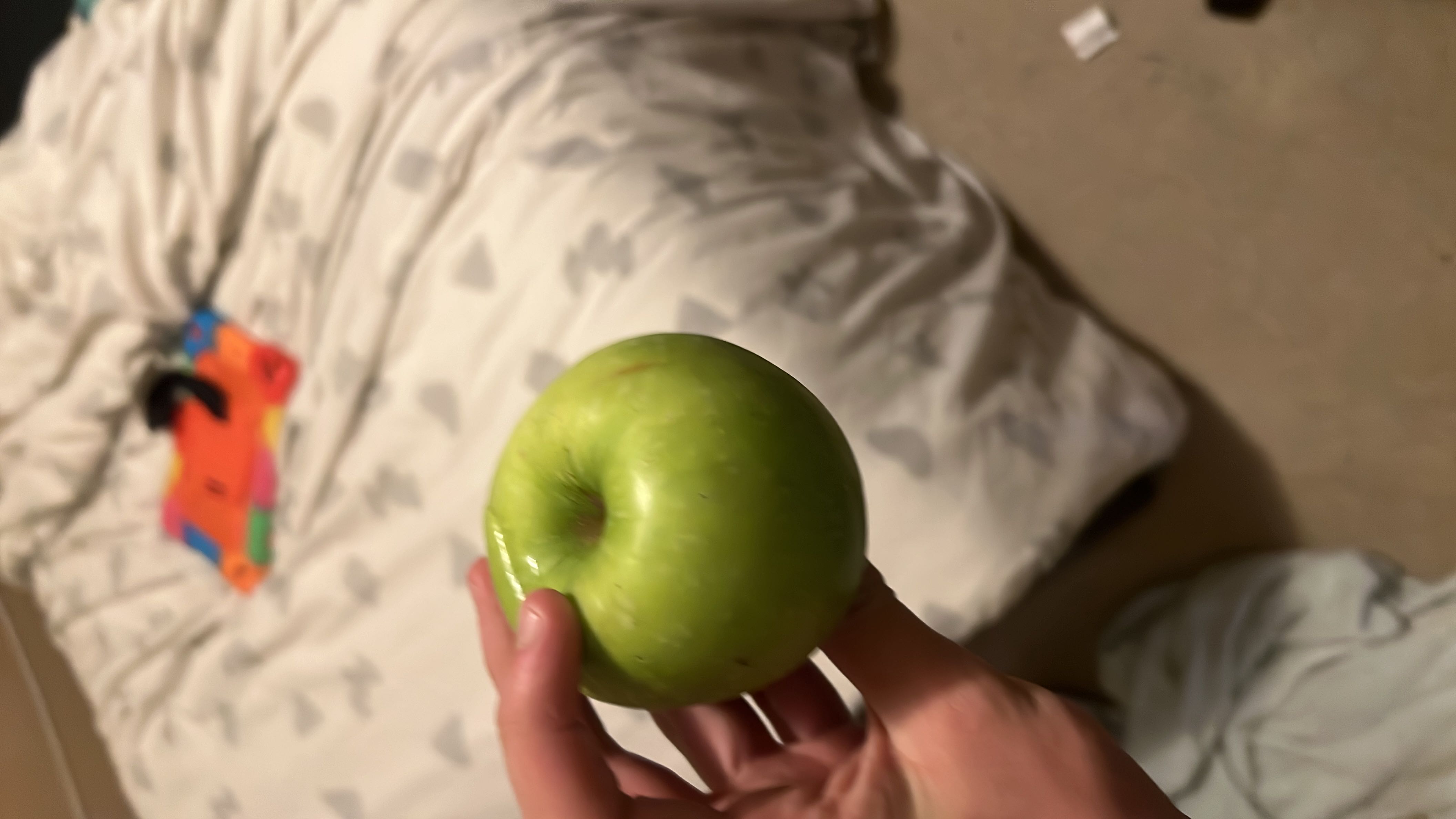 A fresh green apple, a low-calorie fruit rich in carbohydrates and fiber, ideal for a healthy snack.