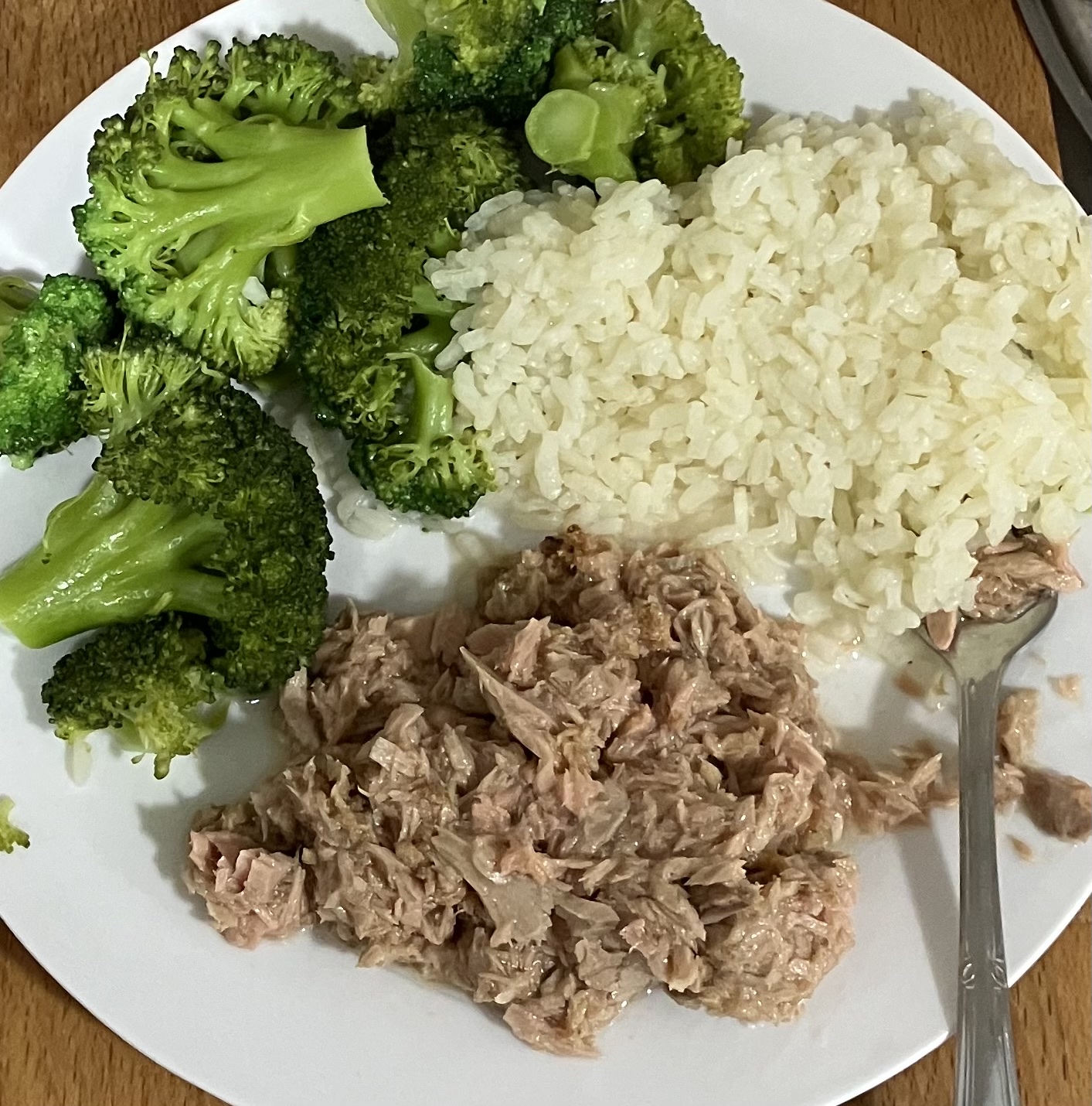 A balanced meal consisting of steamed broccoli, white rice, and canned tuna, providing a good mix of protein, carbohydrates, and fiber.