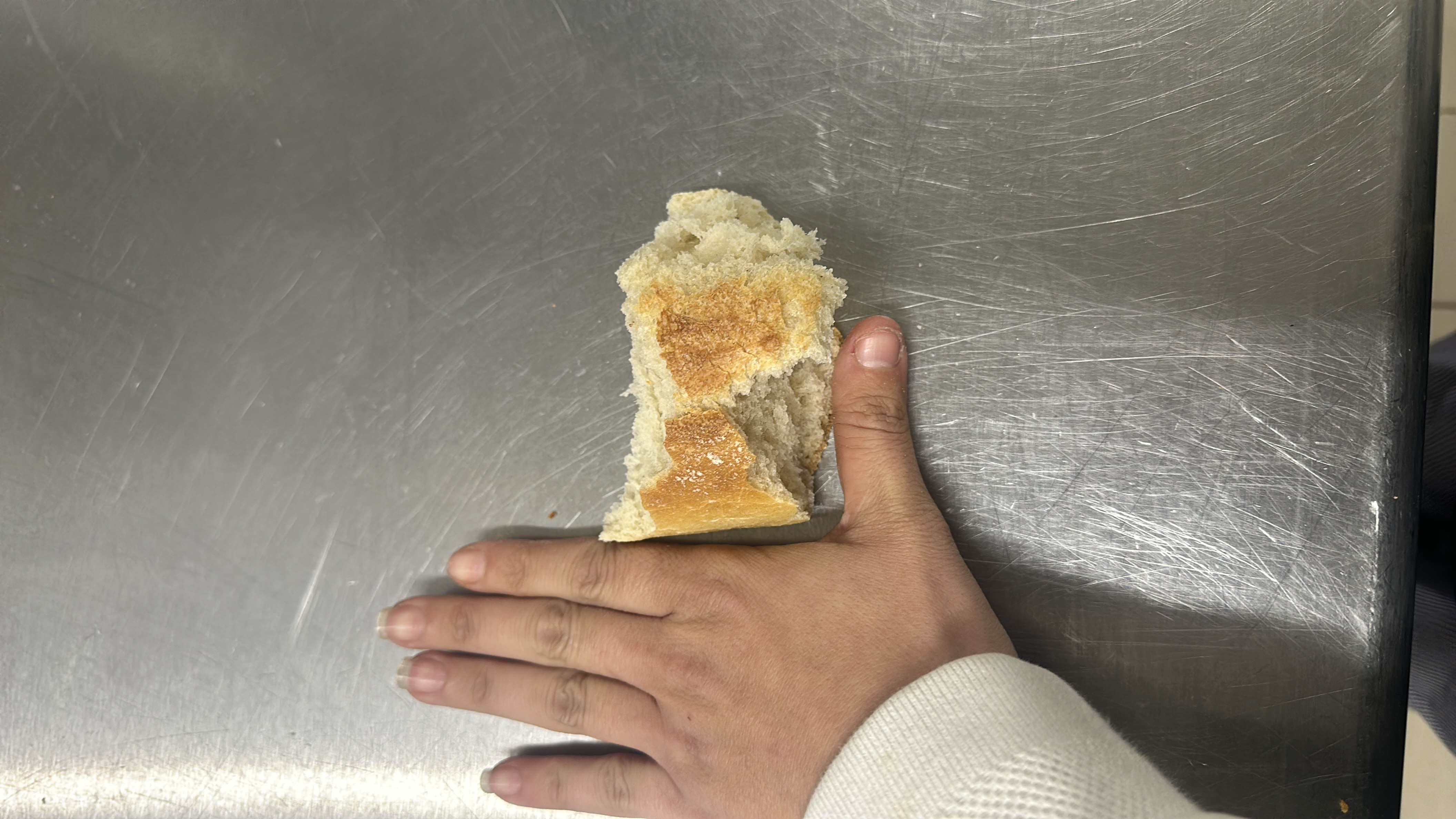 A small piece of bread, likely a white or French bread, with moderate carbohydrate content and minimal protein and fat.