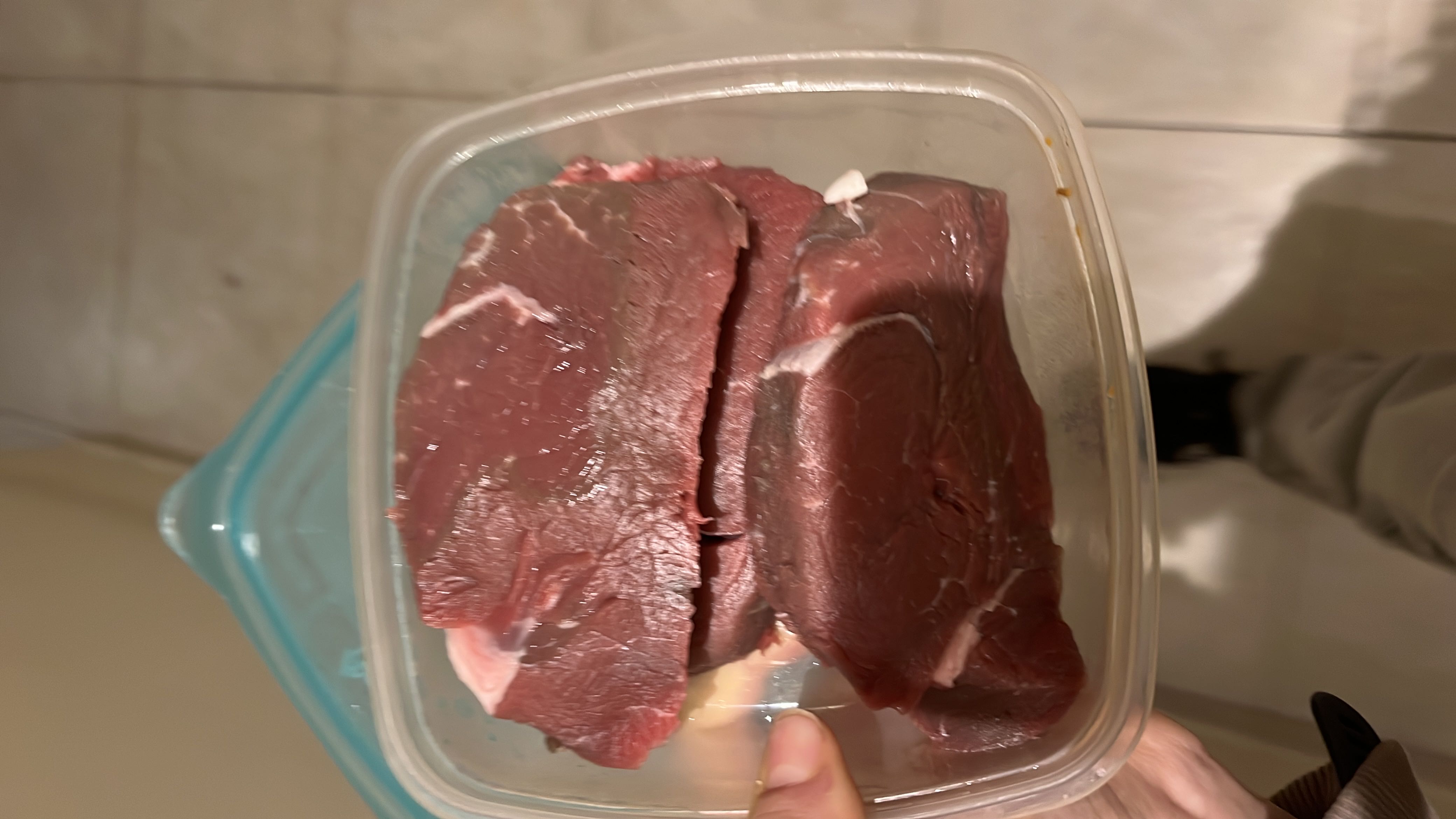 The image shows raw beef steak, which is high in protein and fats, with no carbohydrates.