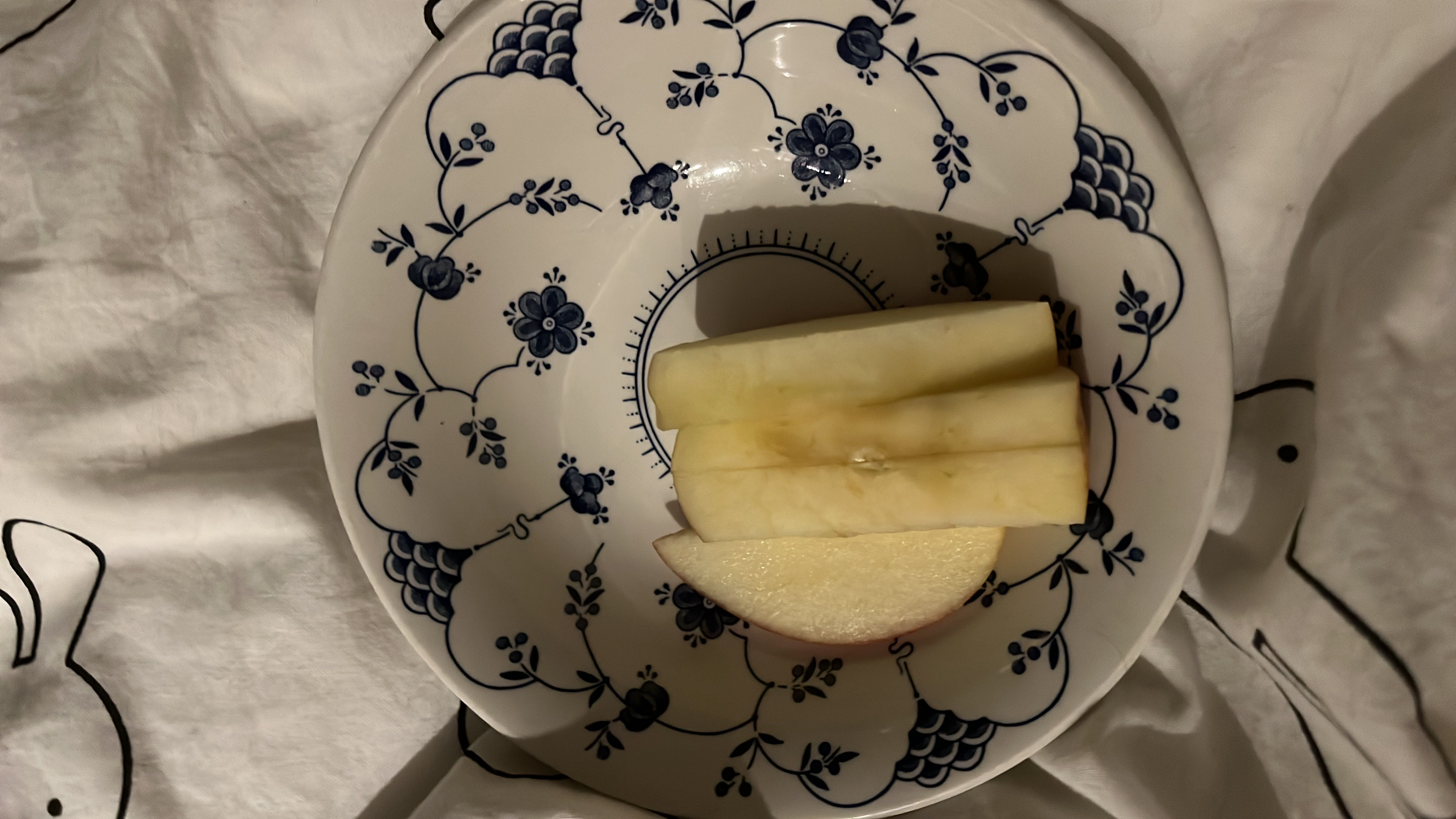 The image shows sliced apple pieces on a decorative plate, providing a healthy and low-calorie snack option.