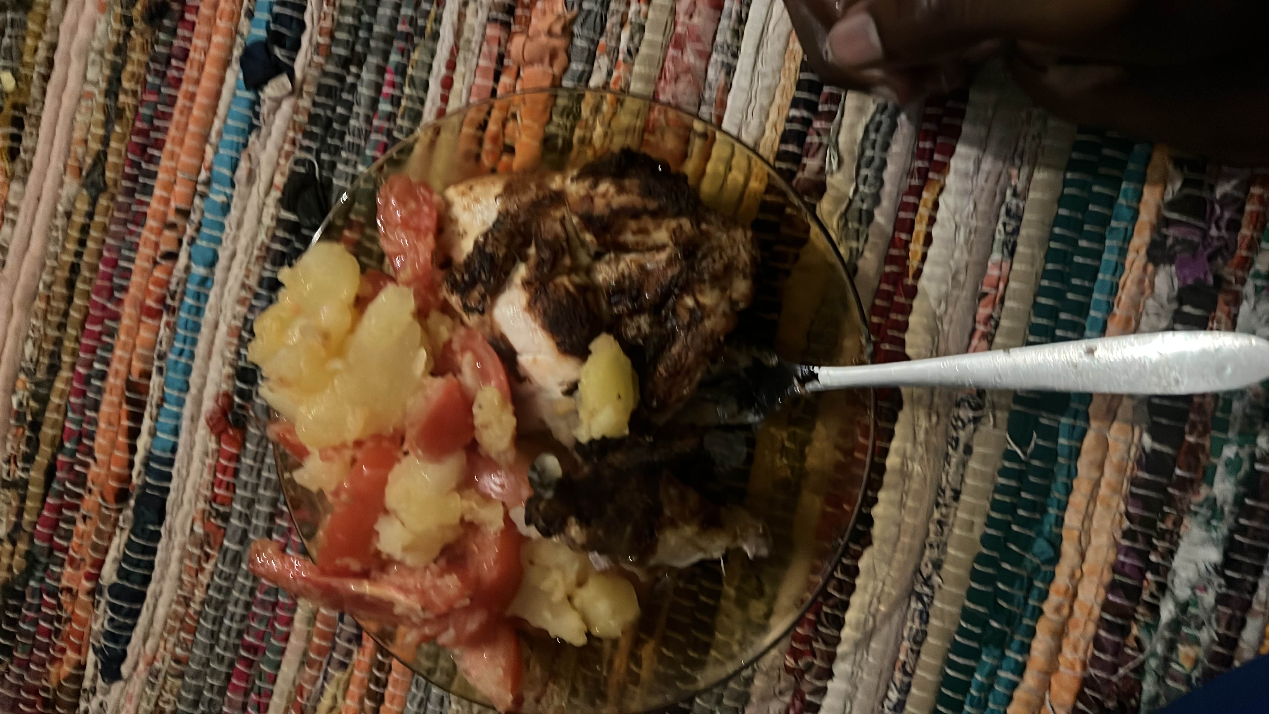 A balanced meal consisting of grilled chicken, potatoes, and fresh tomatoes, providing a good mix of protein, carbs, and fats.