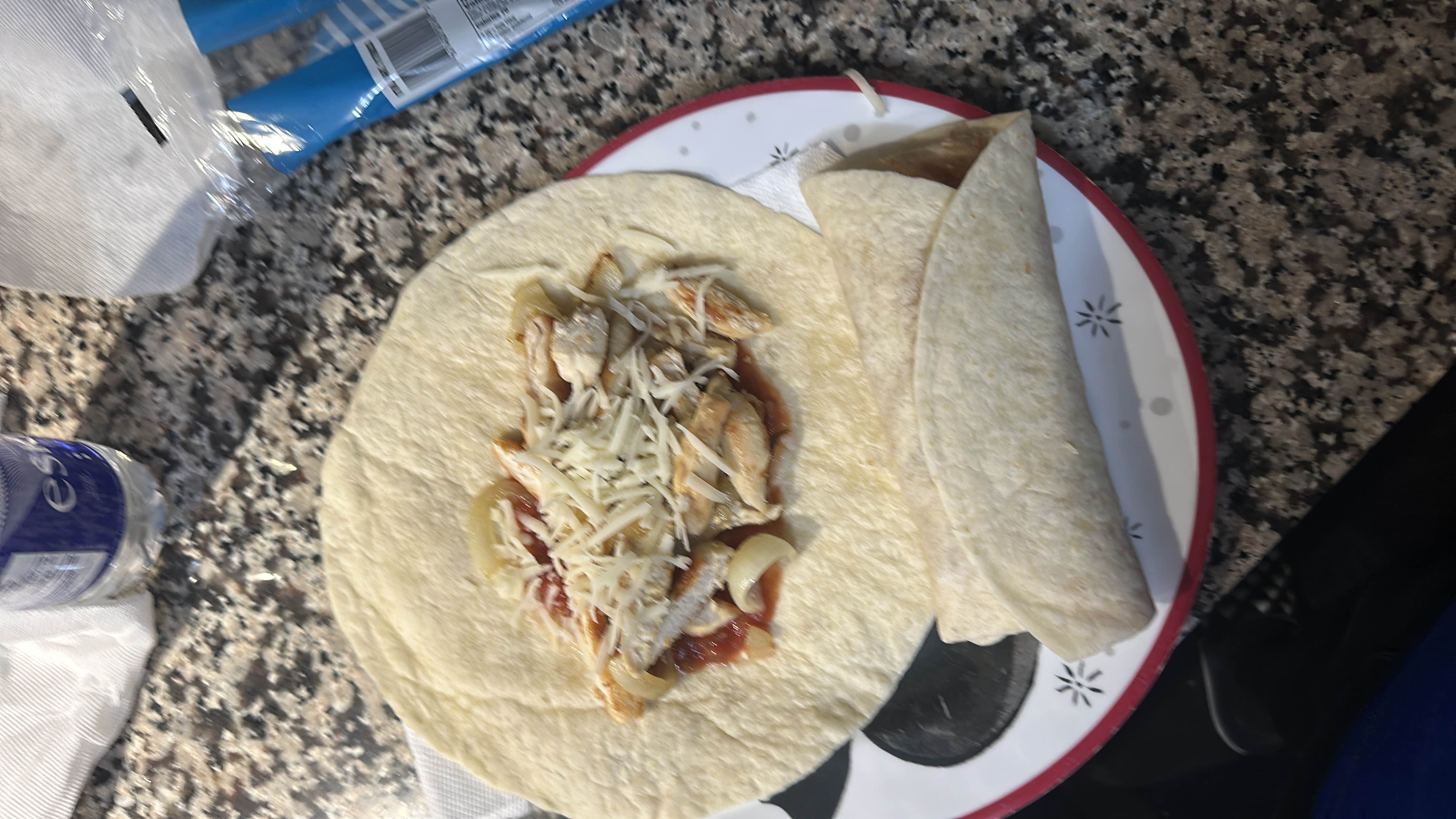 A tortilla wrap filled with chicken, cheese, and salsa, providing a balanced mix of protein, carbs, and fats.