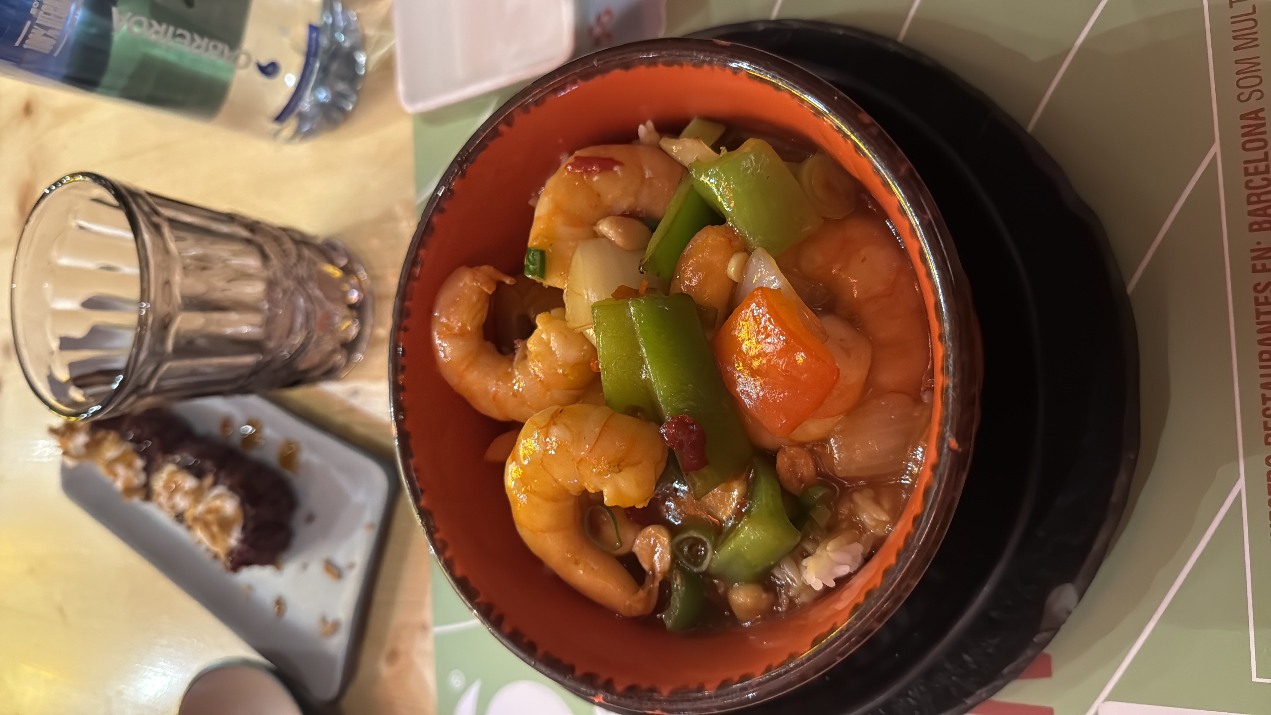 A bowl of shrimp stir-fry with vegetables and rice, served with a flavorful sauce.