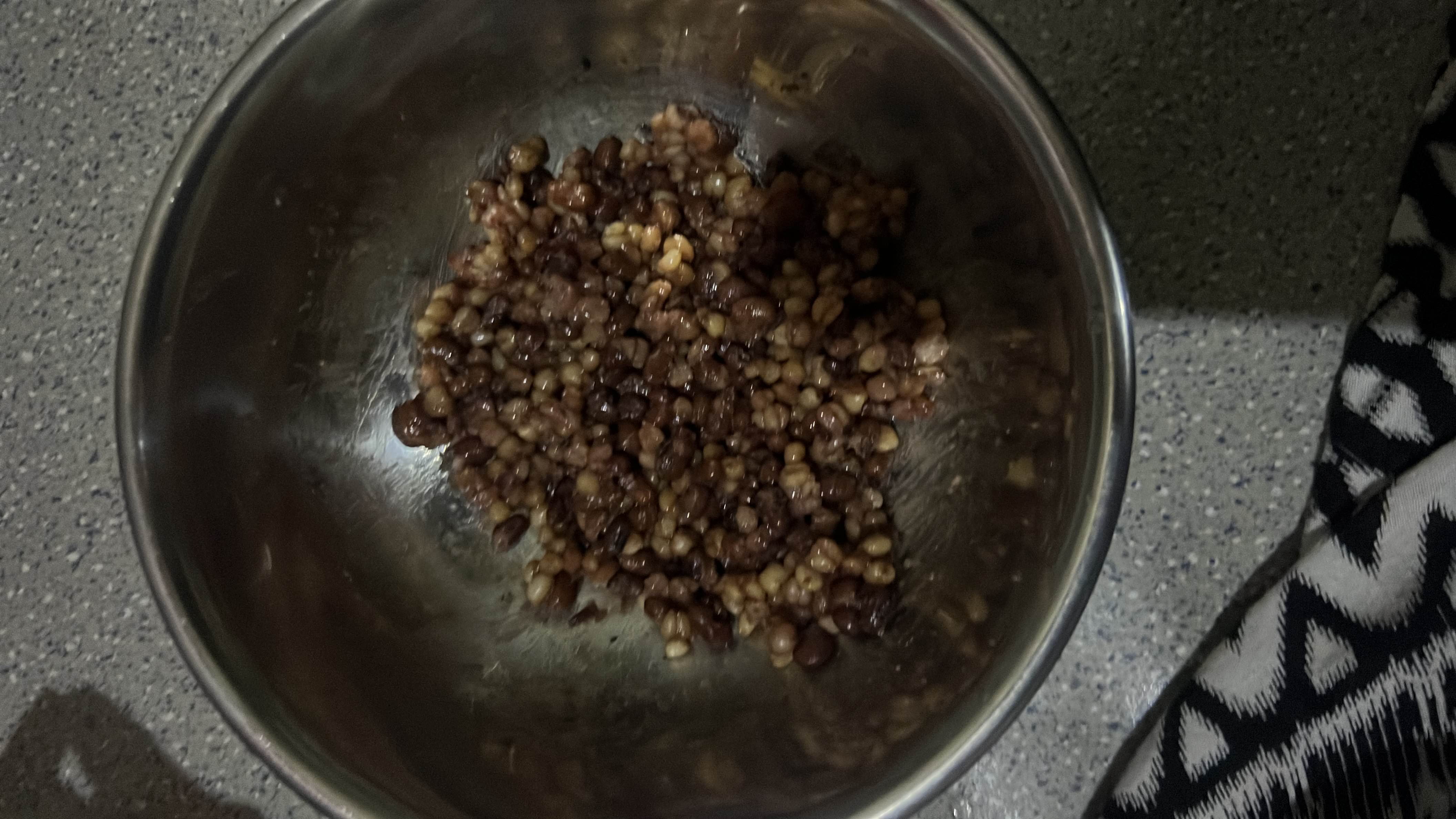 A bowl of cooked lentils, likely seasoned with oil, providing a nutritious and protein-rich meal.