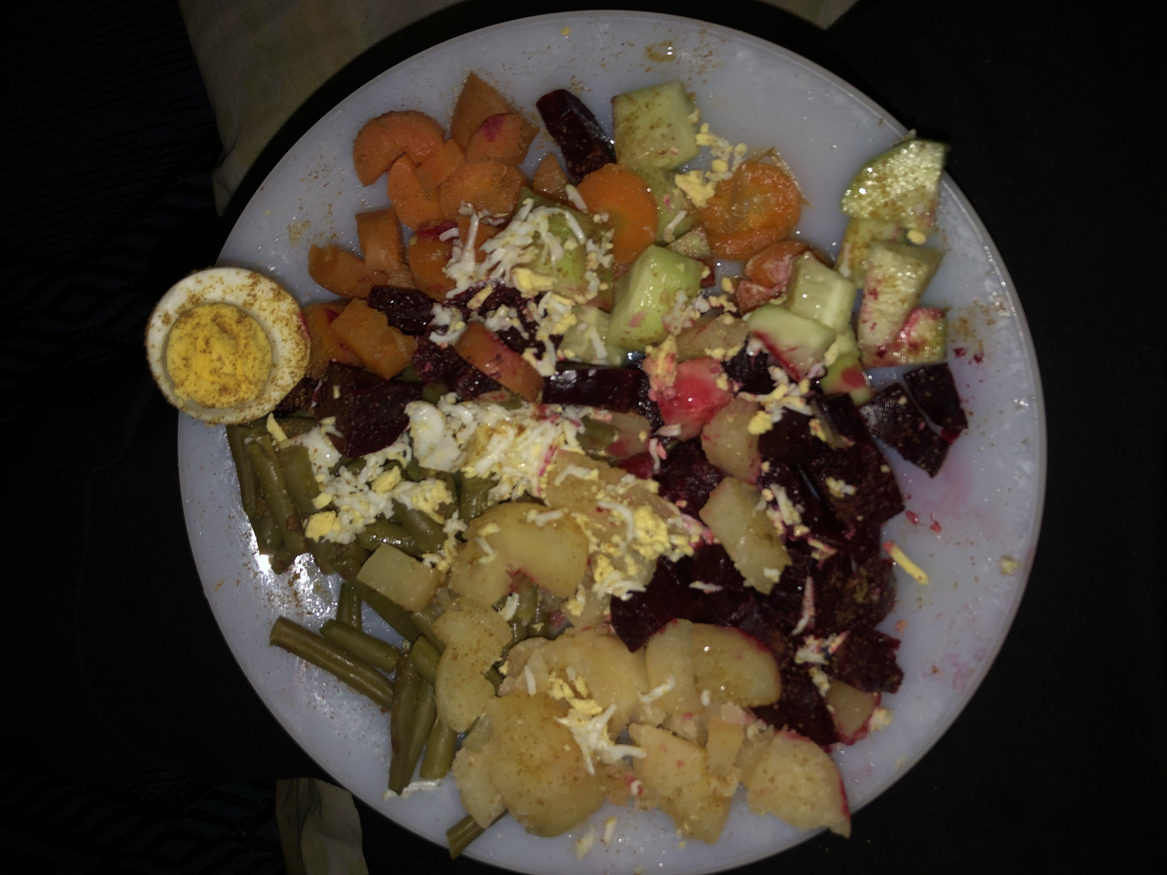 A healthy plate consisting of boiled egg, beetroot, carrot, cucumber, potato, and green beans, providing a balanced mix of protein, carbs, and fats.