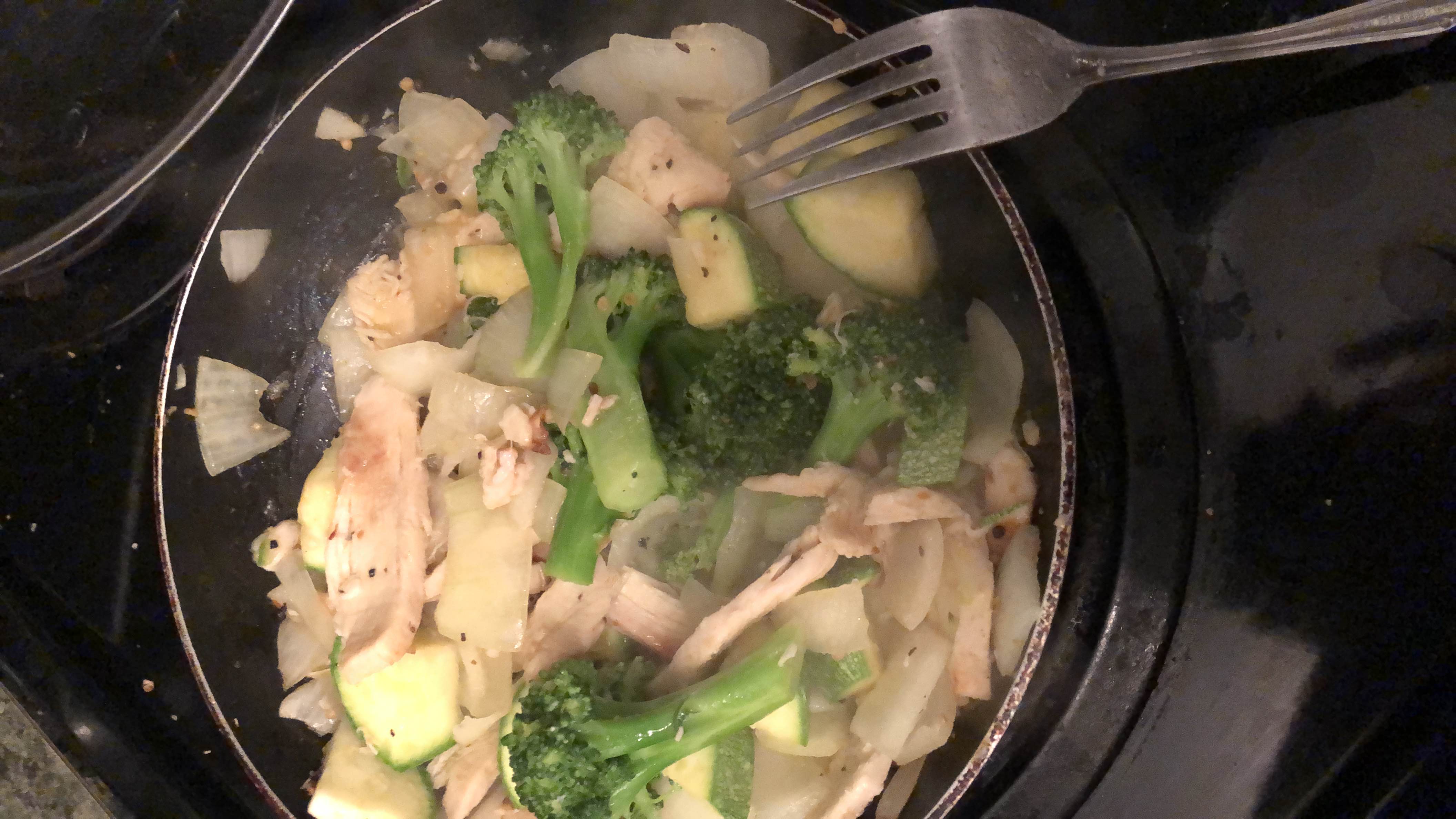 A healthy stir-fry dish with chicken breast, broccoli, zucchini, and onions, providing a balanced mix of protein, carbs, and fats.
