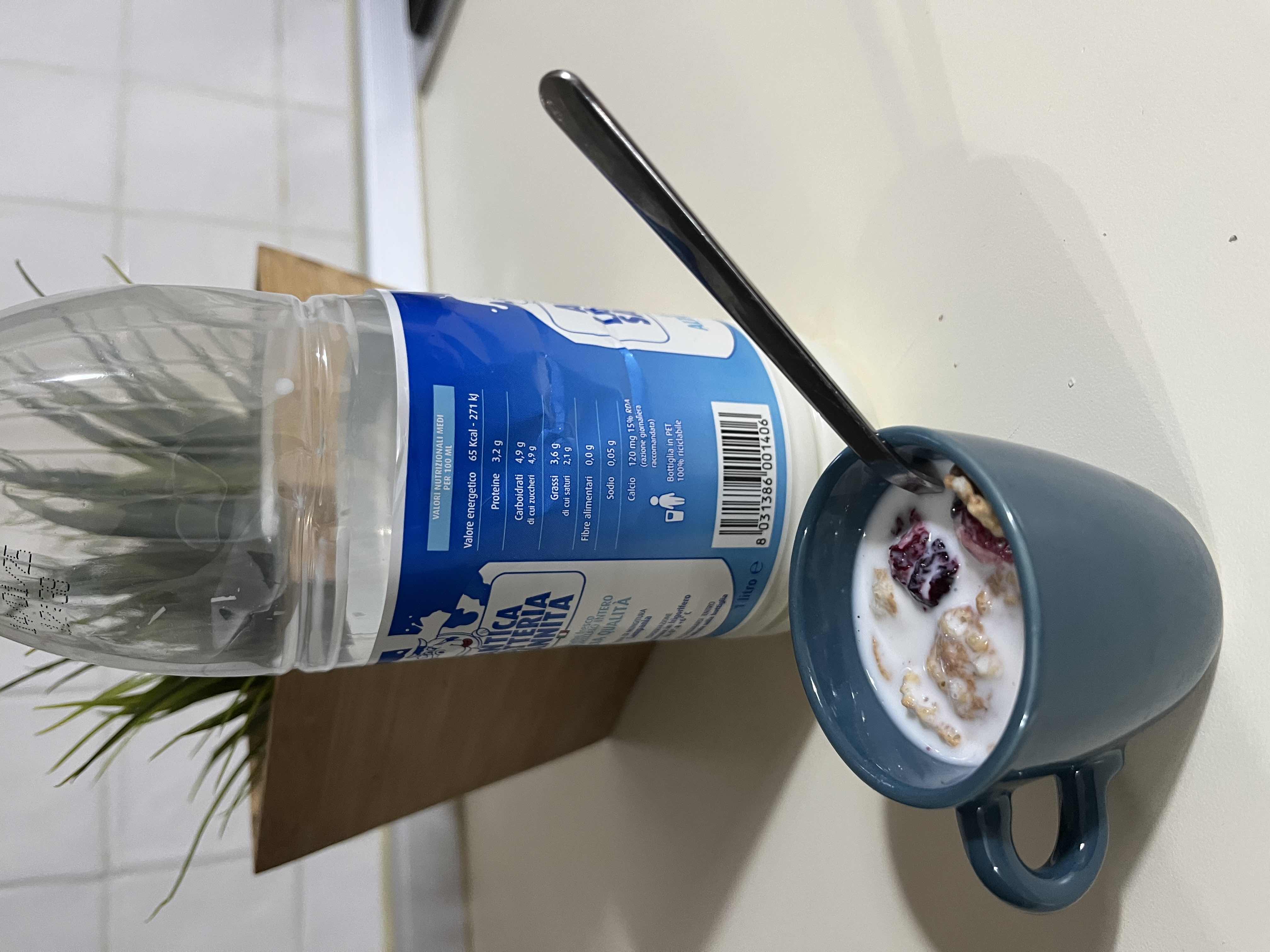 A cup of milk with cereal and dried berries, providing a balanced mix of protein, carbs, and fats.