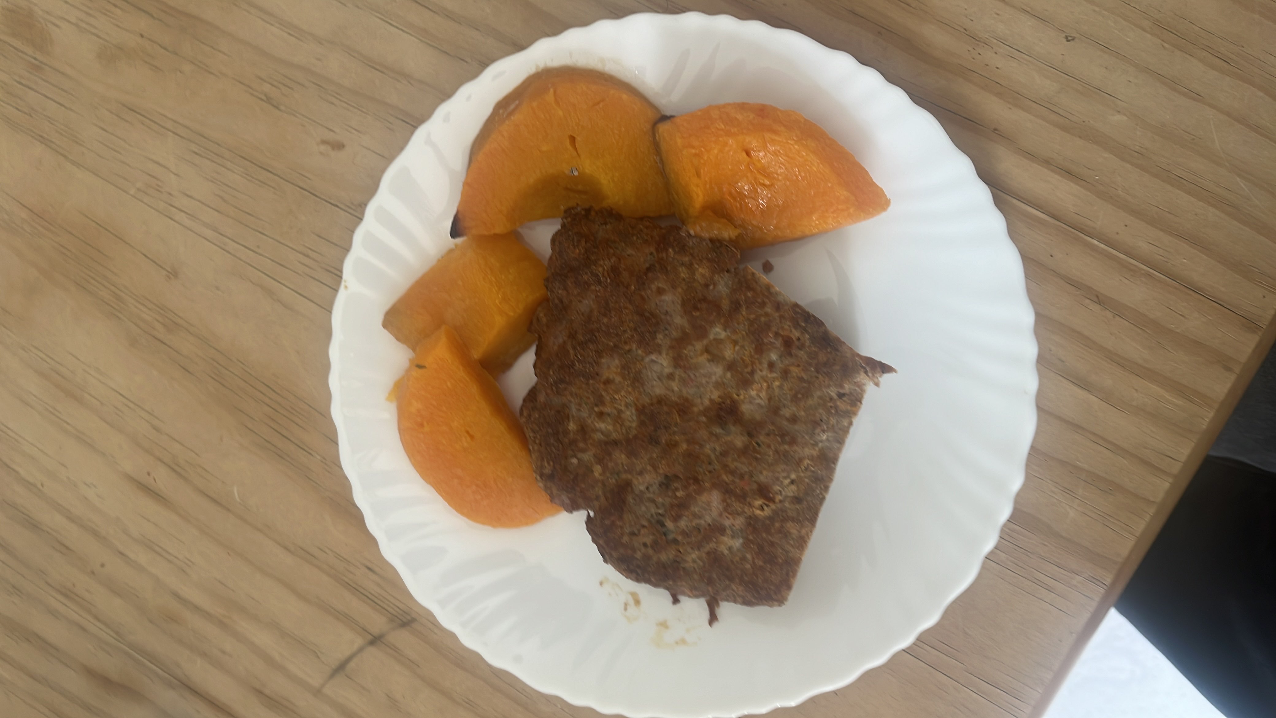 A plate containing grilled meat and roasted pumpkin, providing a balanced mix of protein, carbs, and fats.
