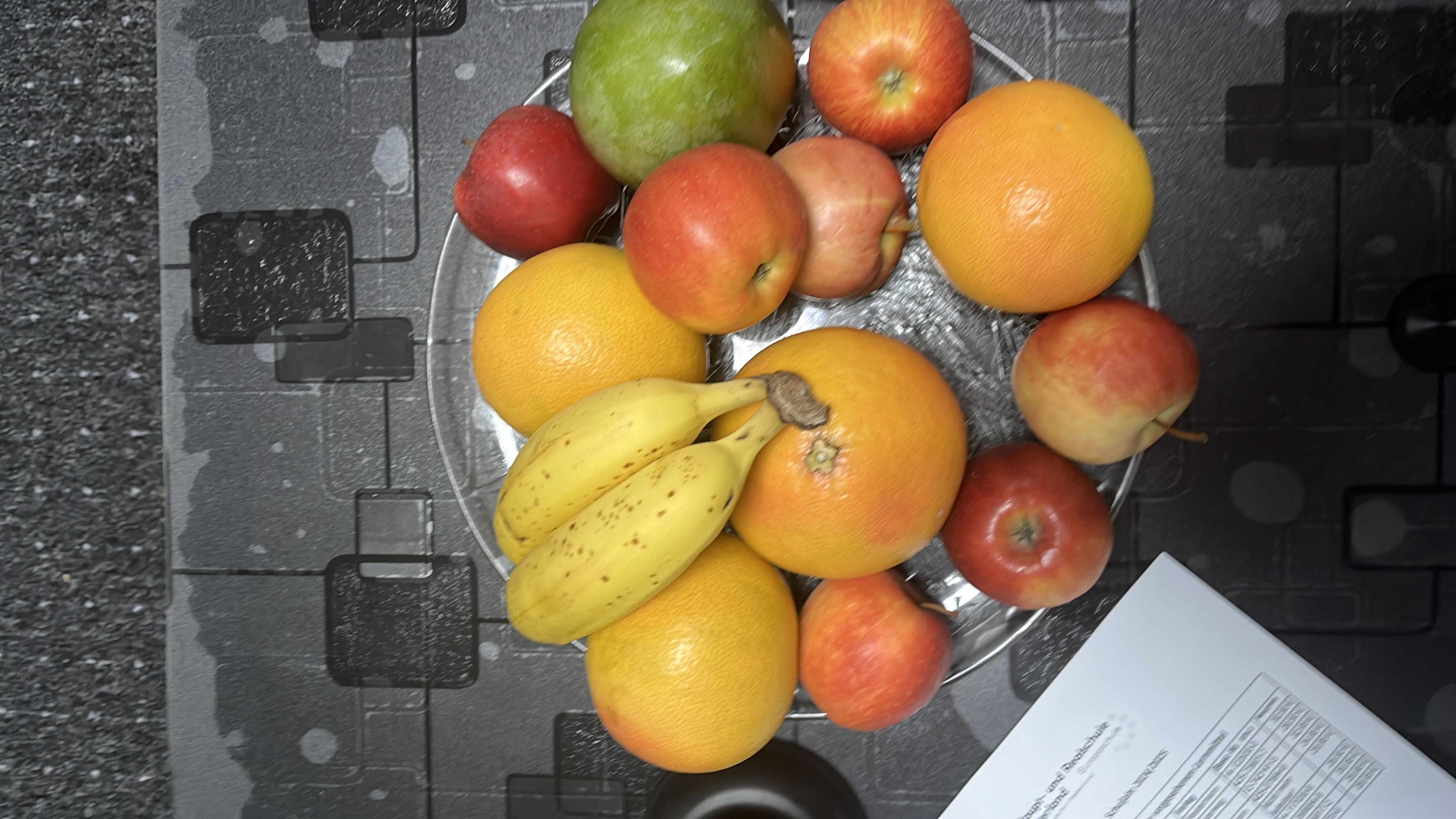 A plate of fresh fruits including bananas, apples, grapefruits, and a pear, providing a healthy mix of carbohydrates, minimal fats, and some protein.