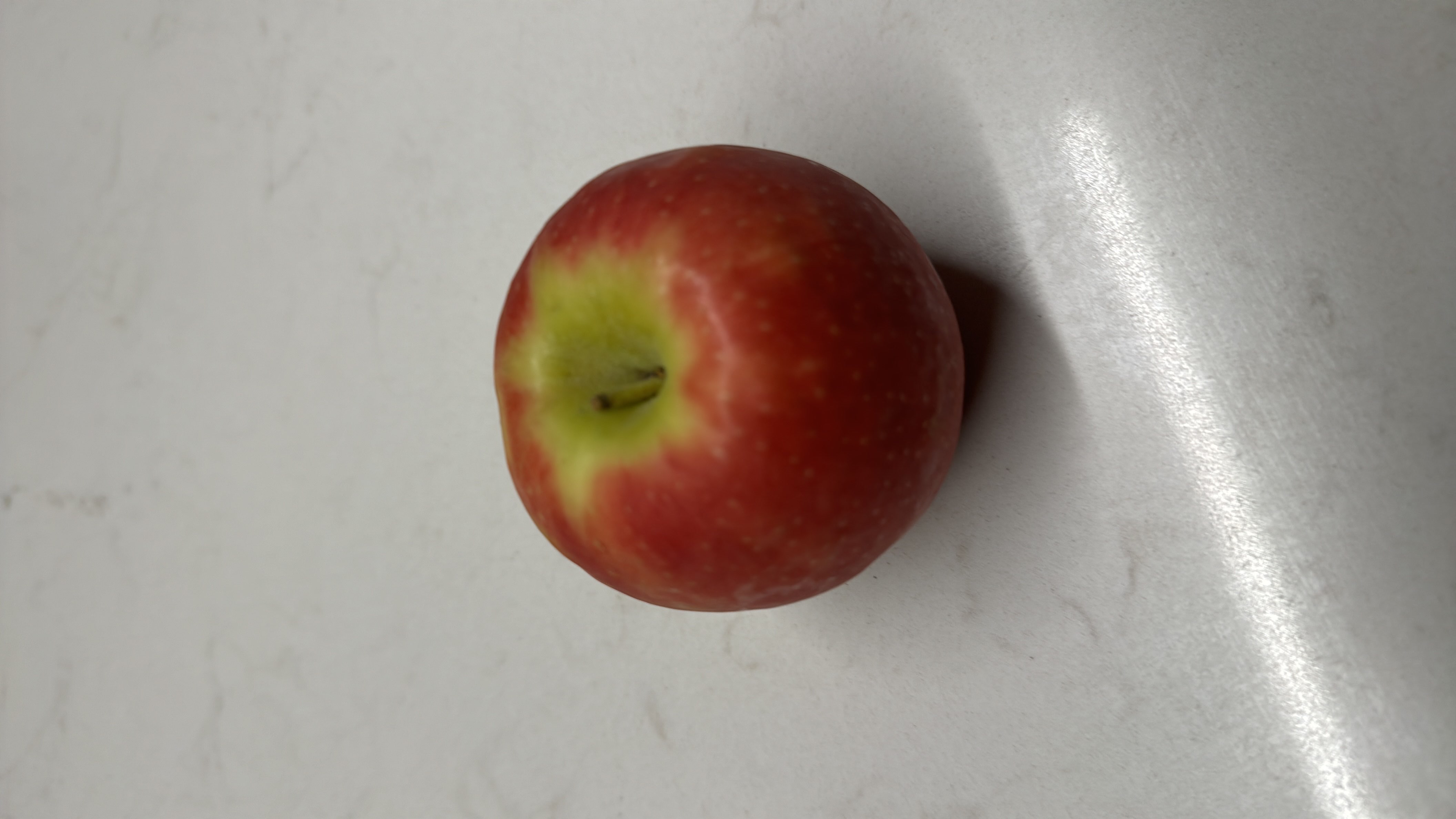 A fresh apple, which is a low-calorie fruit rich in carbohydrates and dietary fiber, making it a healthy snack option.