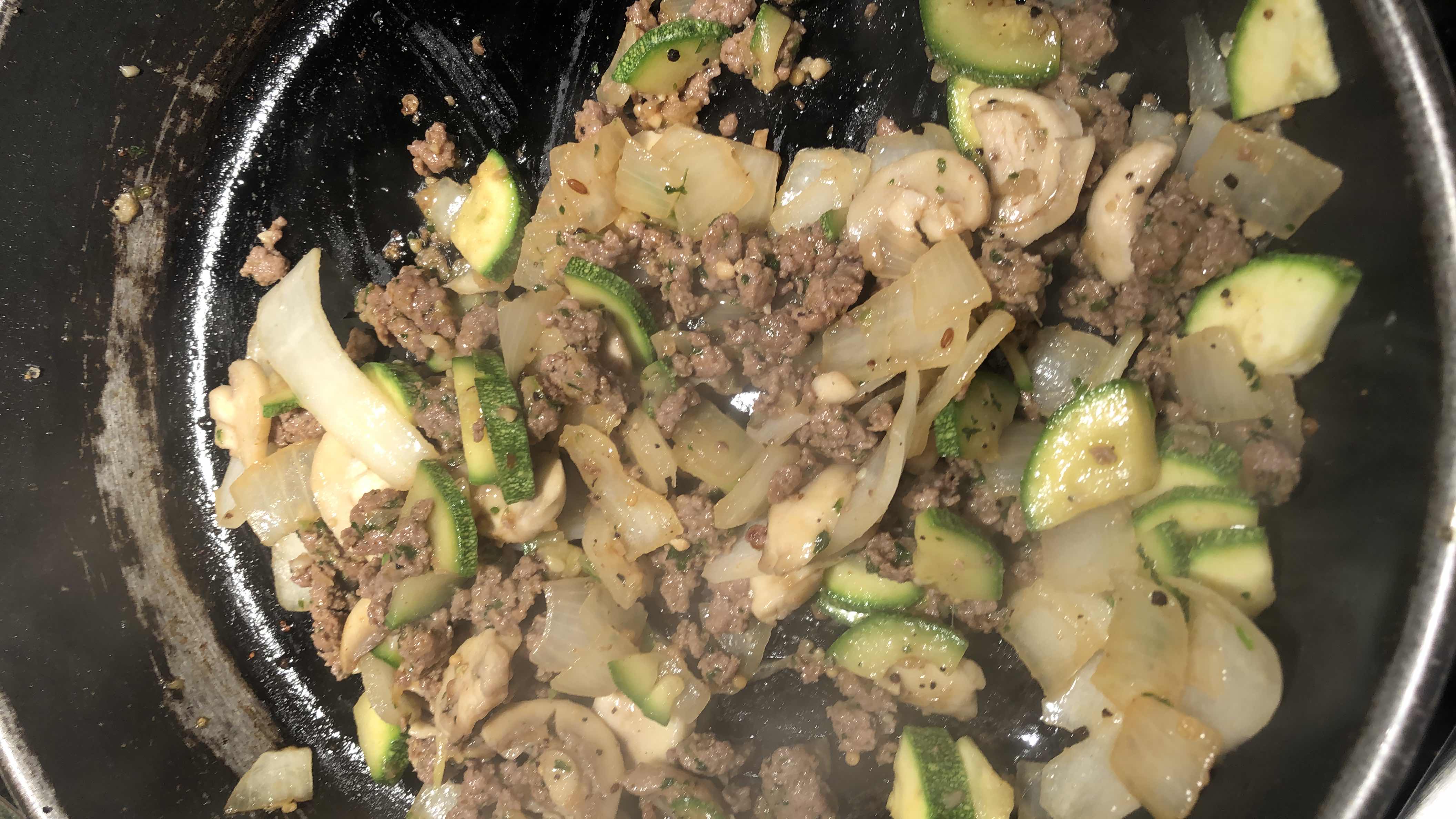 A sautéed dish containing ground beef, zucchini, onions, mushrooms, and spices, offering a balanced mix of protein, fats, and carbs.