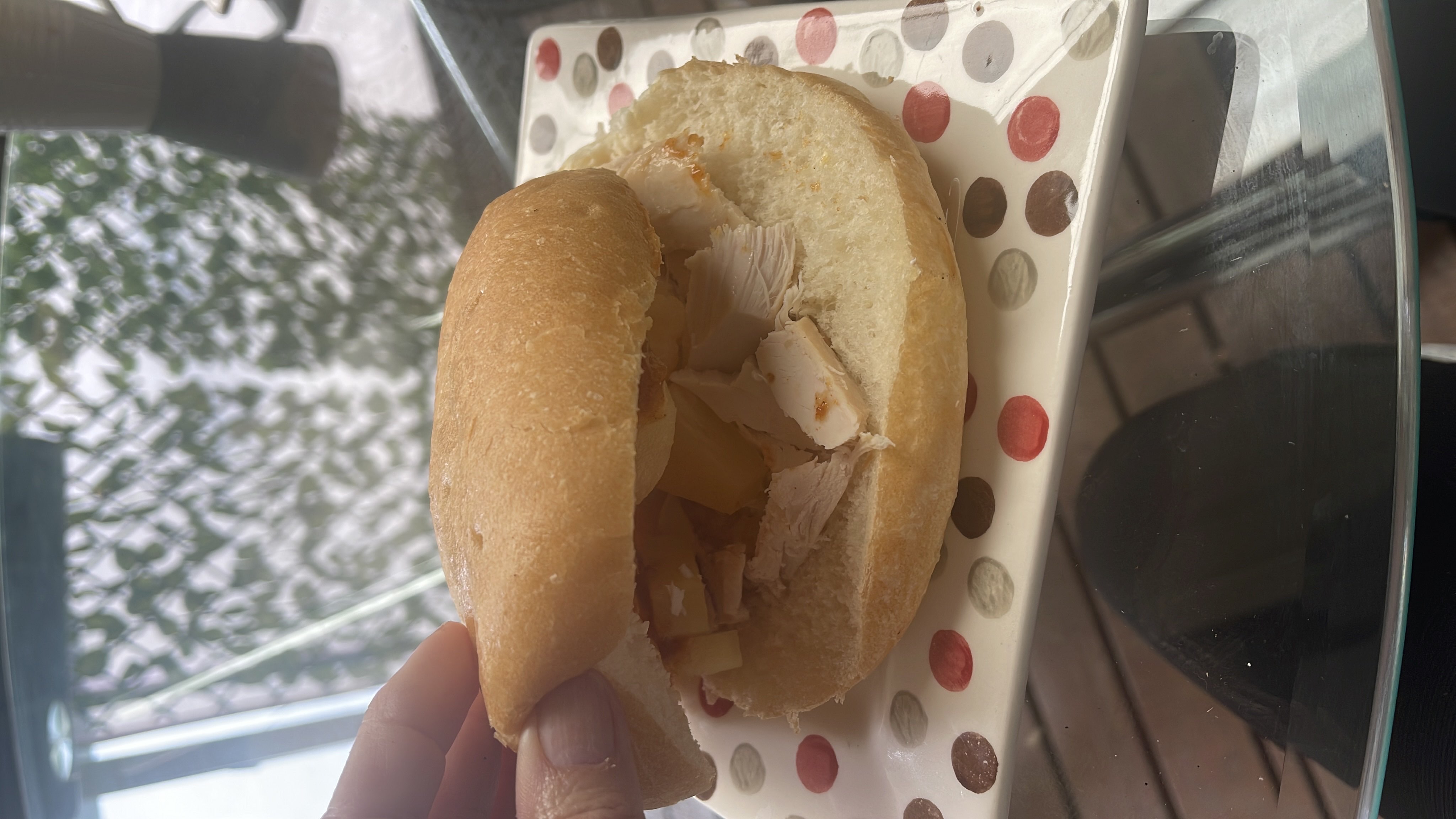 A sandwich made with a bread roll, chicken slices, and potato slices, offering a balanced mix of protein, carbs, and fats.