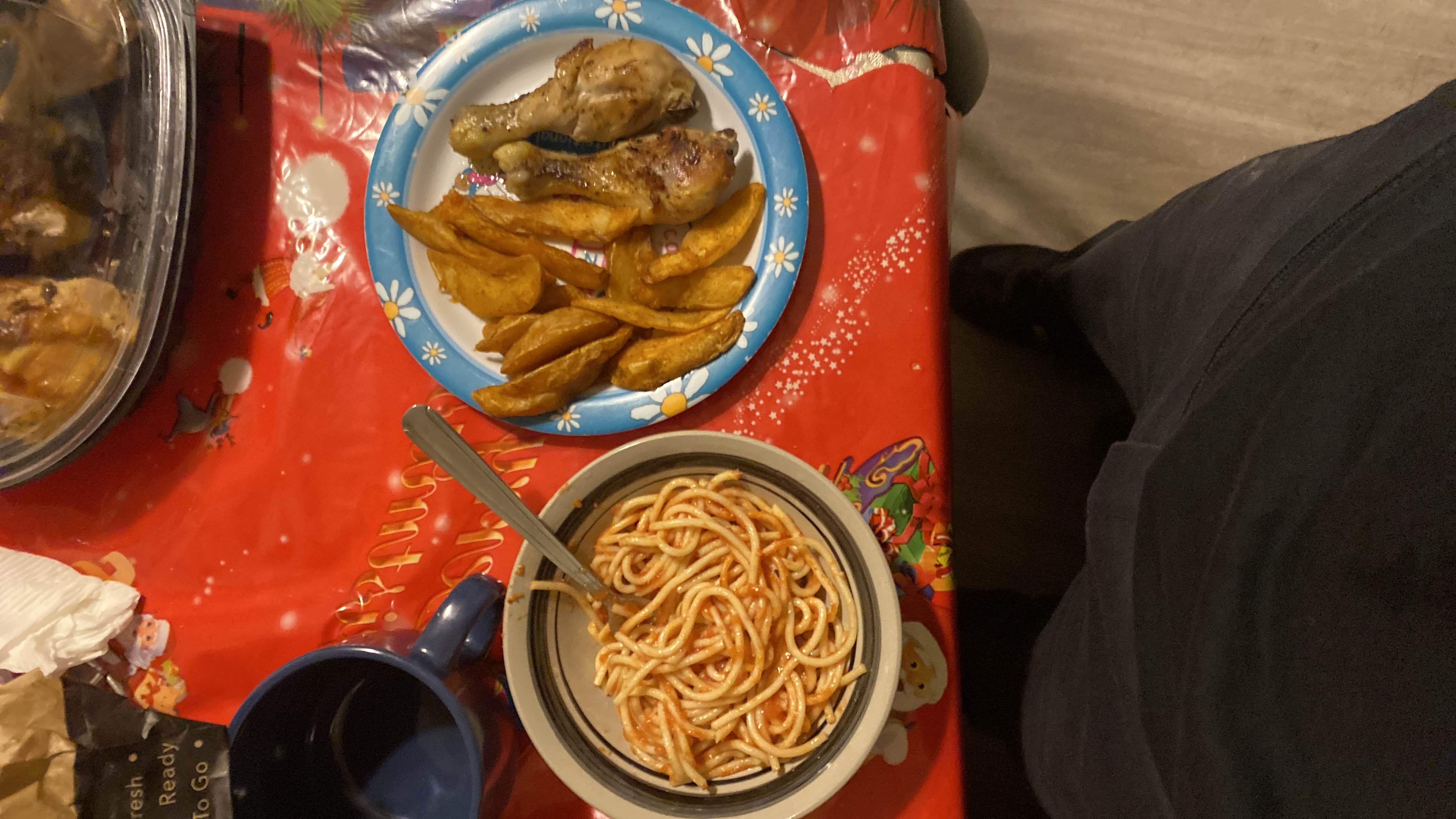 A meal consisting of spaghetti with tomato sauce, potato wedges, and grilled chicken drumsticks, providing a balanced mix of protein, carbs, and fats.